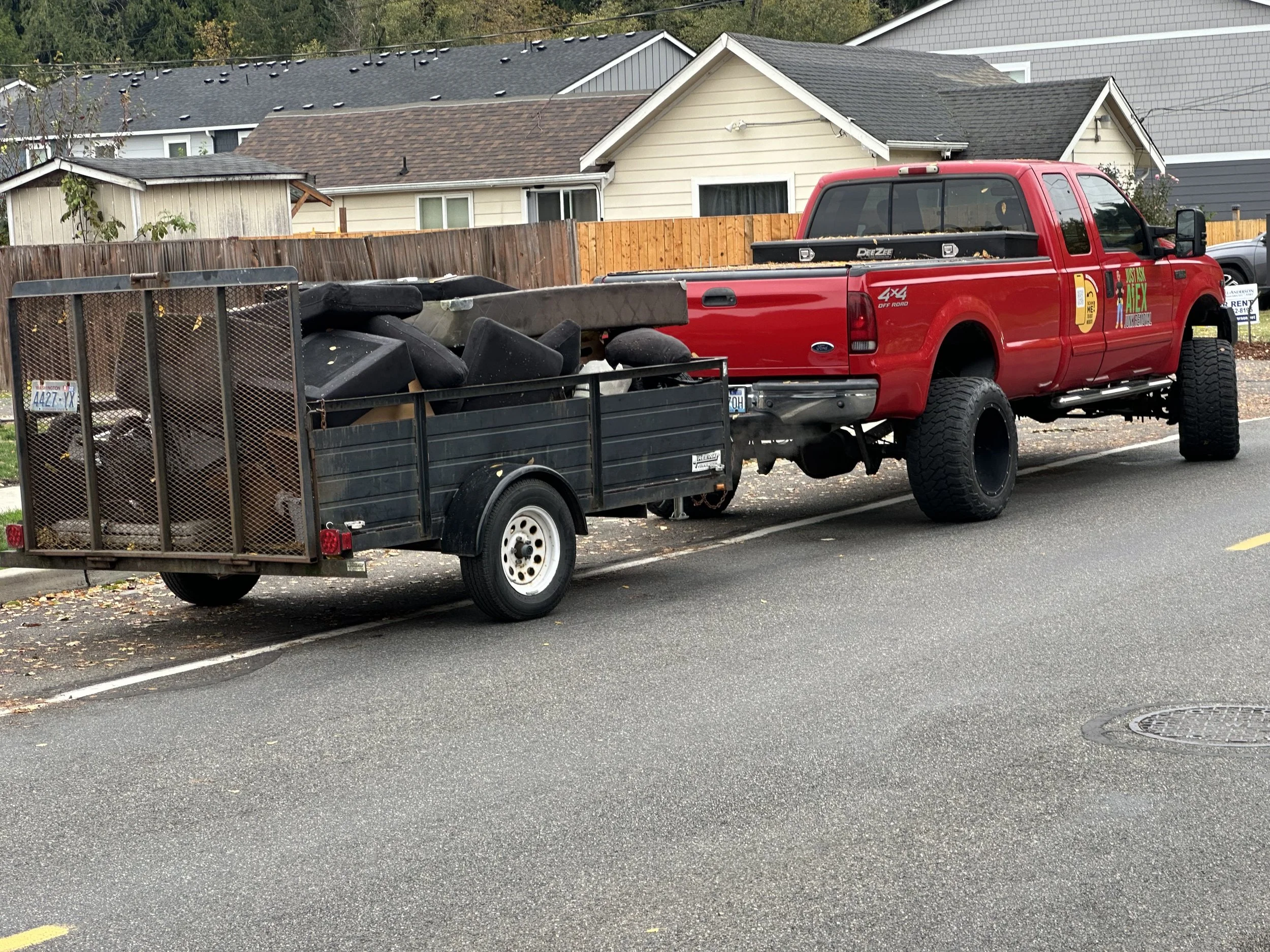 Black trailer loaded with old couches ready for hauling and disposal in Auburn, Washington.