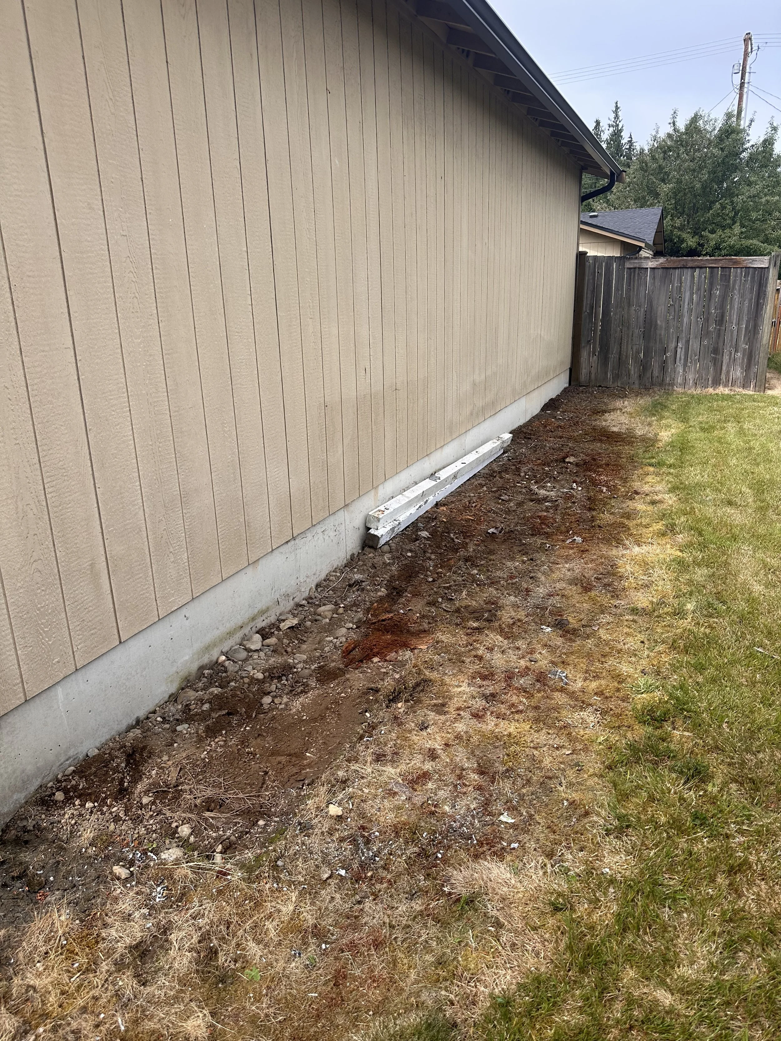 Side yard after removal of old lumber and bulky building materials beside a residential home in Puyallup, WA.