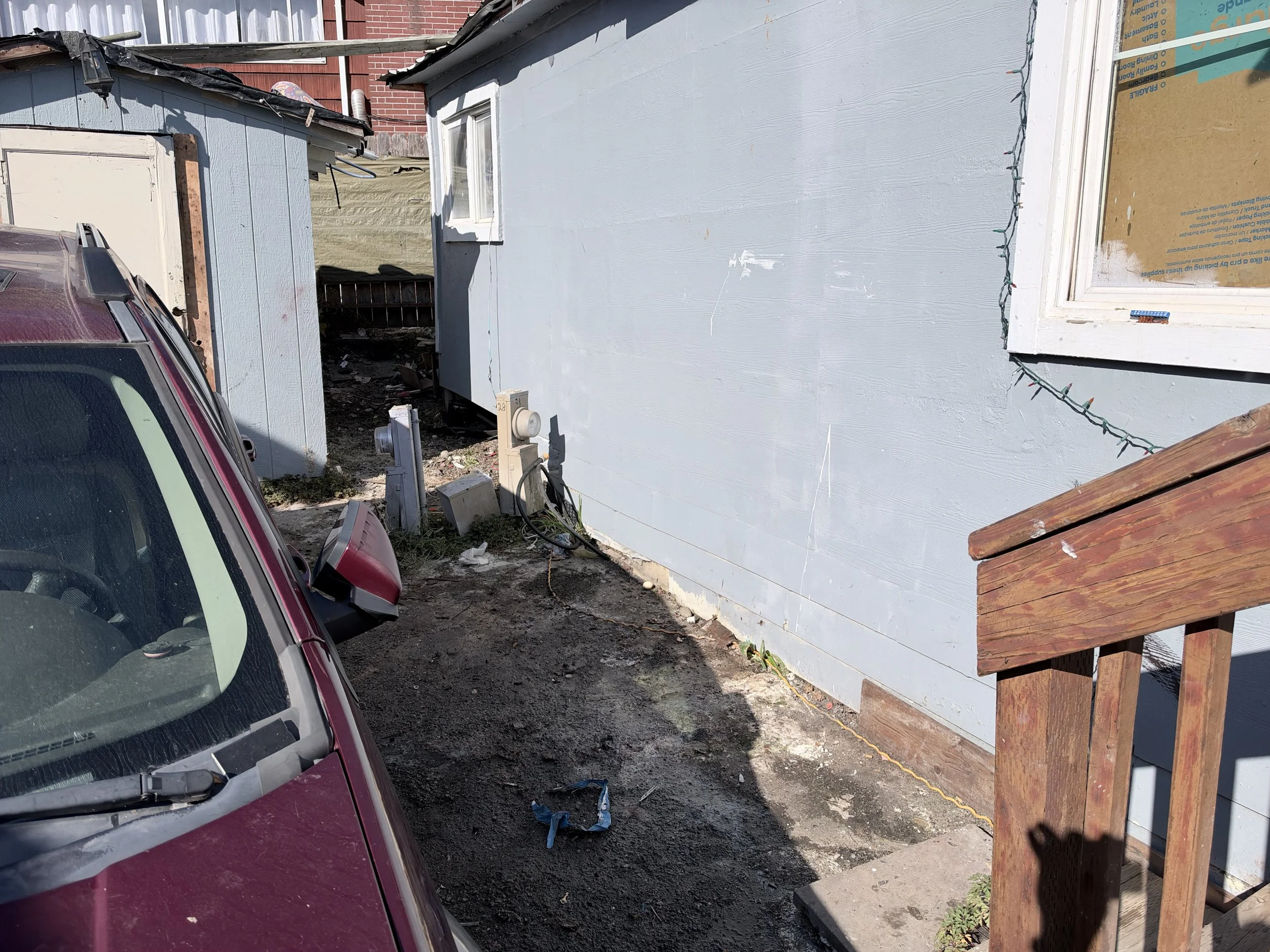Narrow passage between residential buildings in Tukwila after removal of abandoned items and household junk.