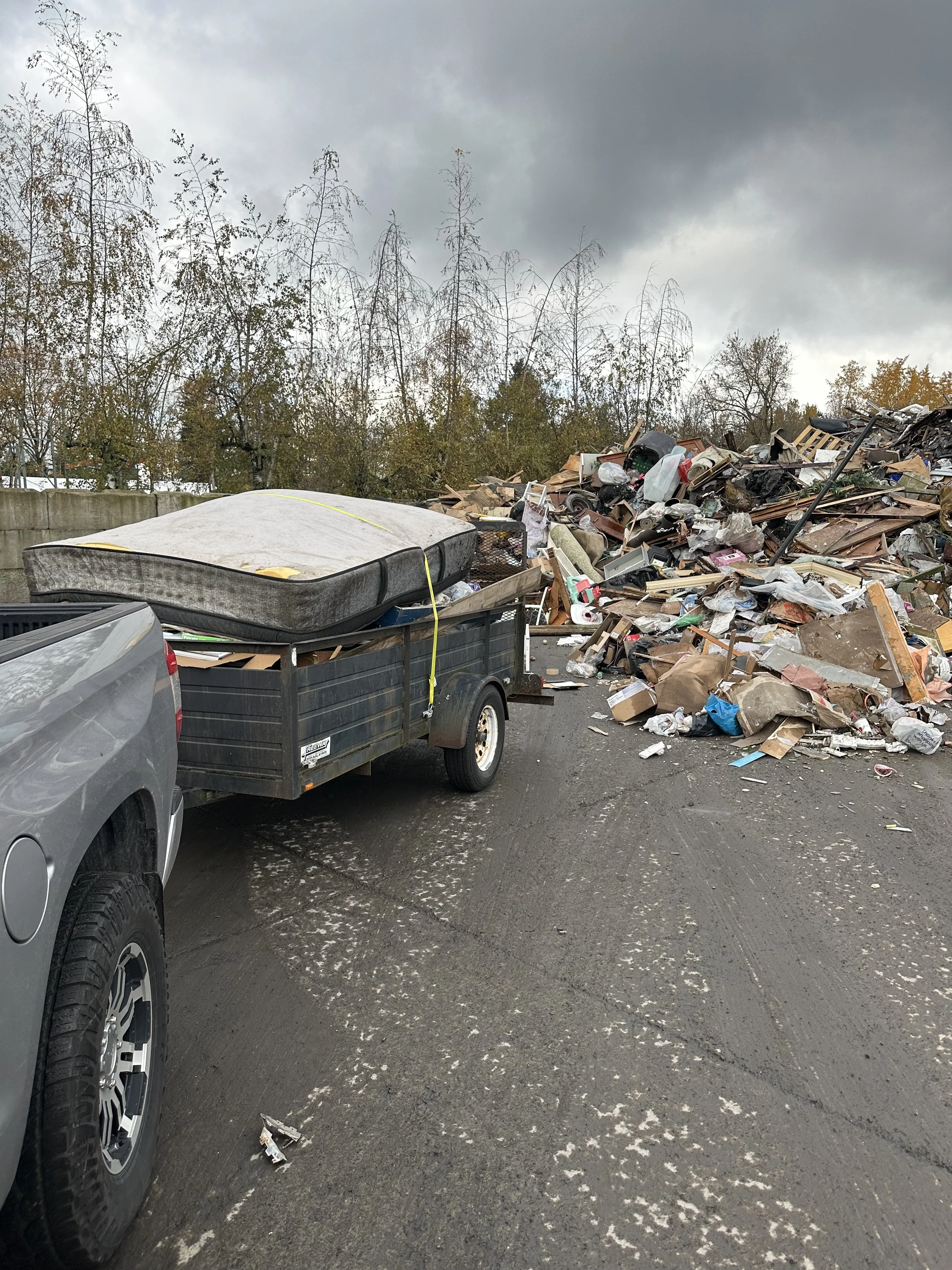 Truck and trailer unloading a mattress and mixed waste at the Tacoma dump.