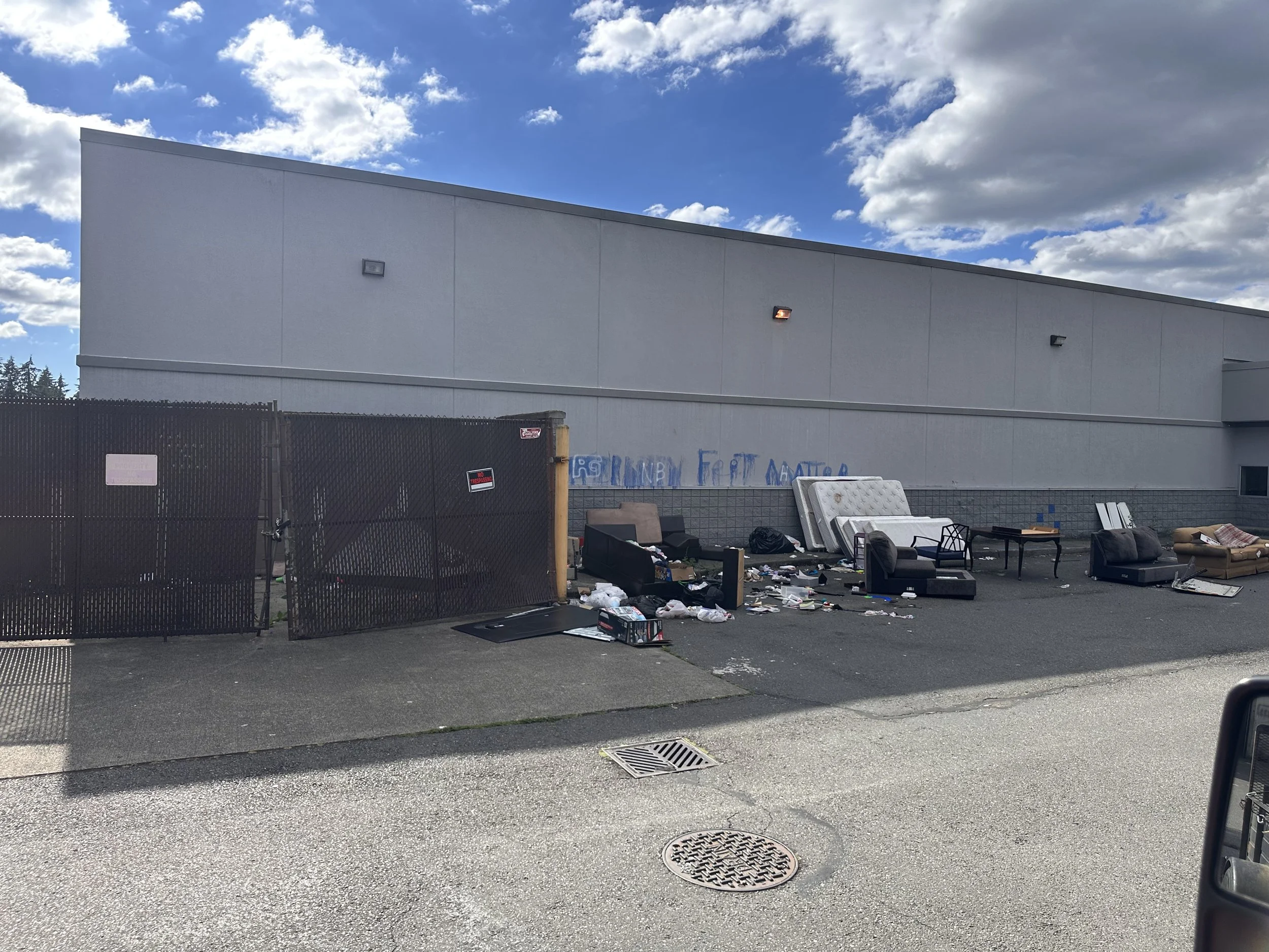 Illegal dumping behind former Rite Aid commercial property in Puyallup, WA, before cleanup by Just Ask Alex Junk Removal