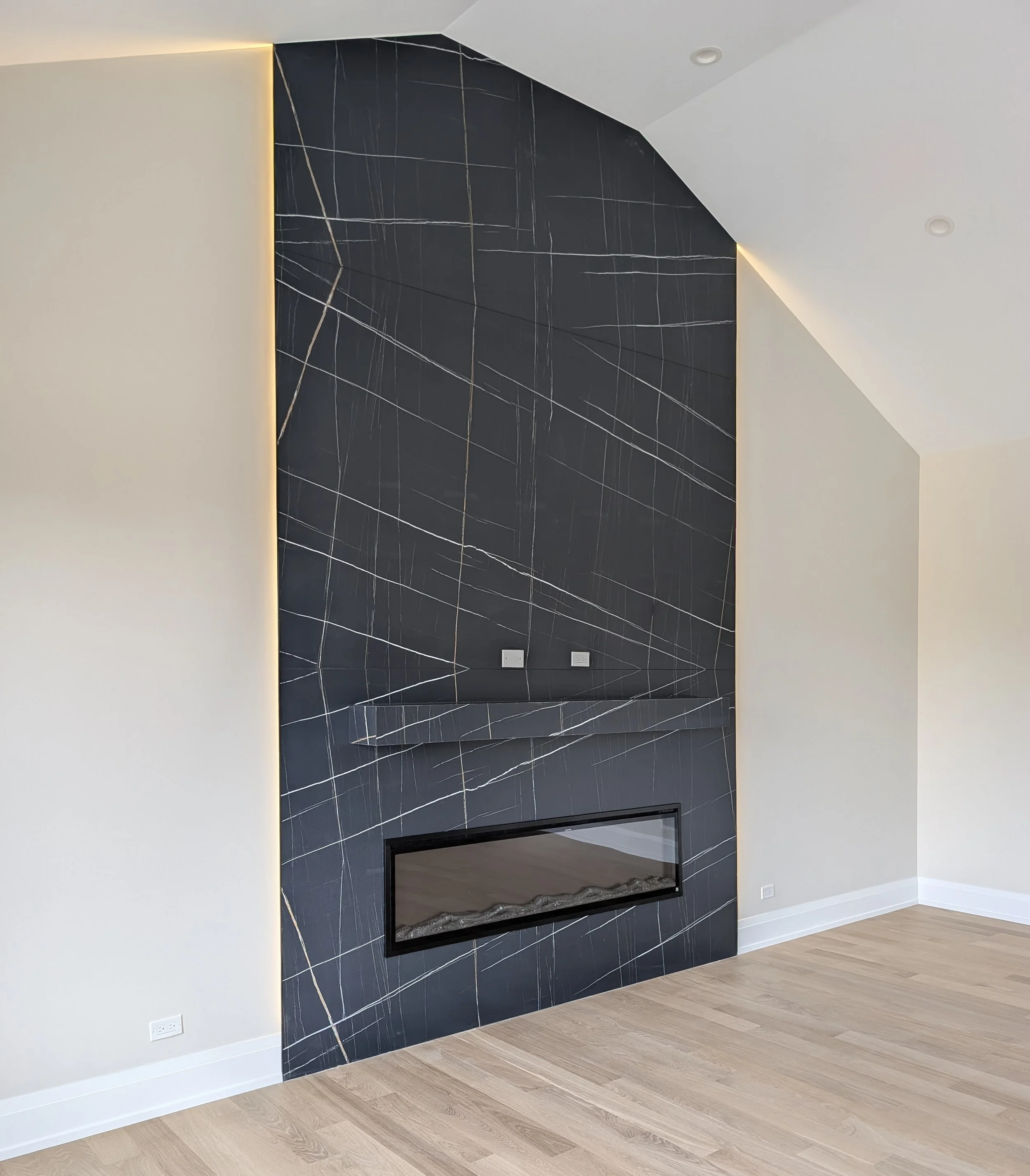 Custom Floor-to-ceiling fireplace with large-format black porcelain tile installed by Dream Luxe Remodeling in the Chicago area