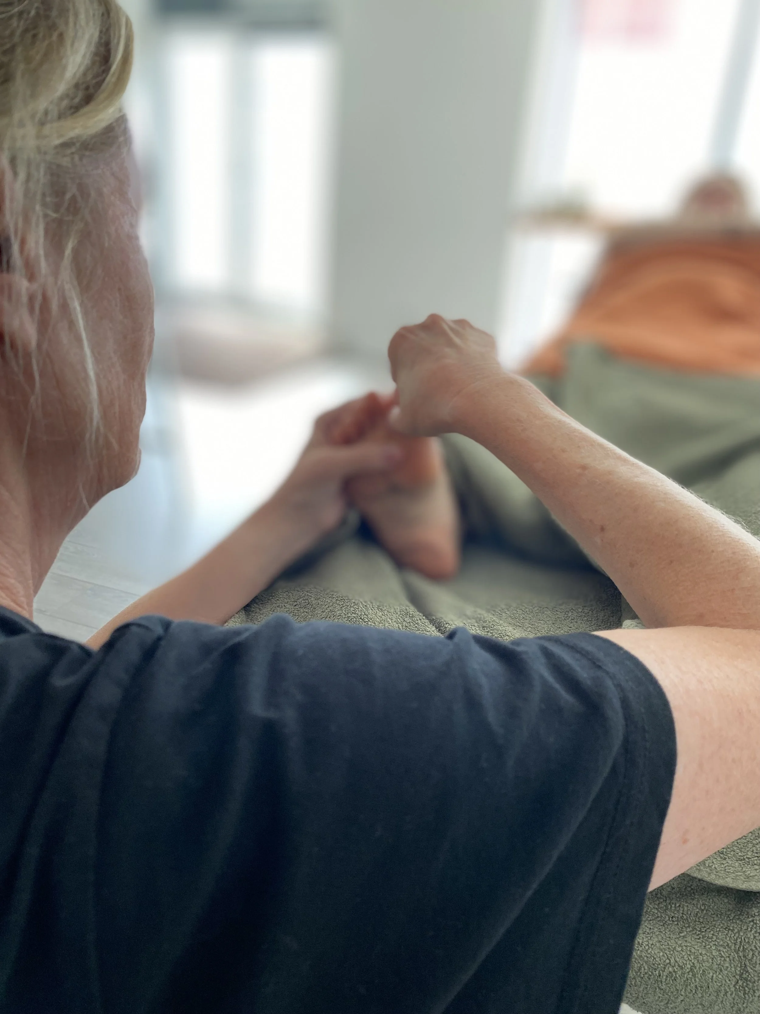 A person is receiving a massage on their back in a spa or massage therapy setting.