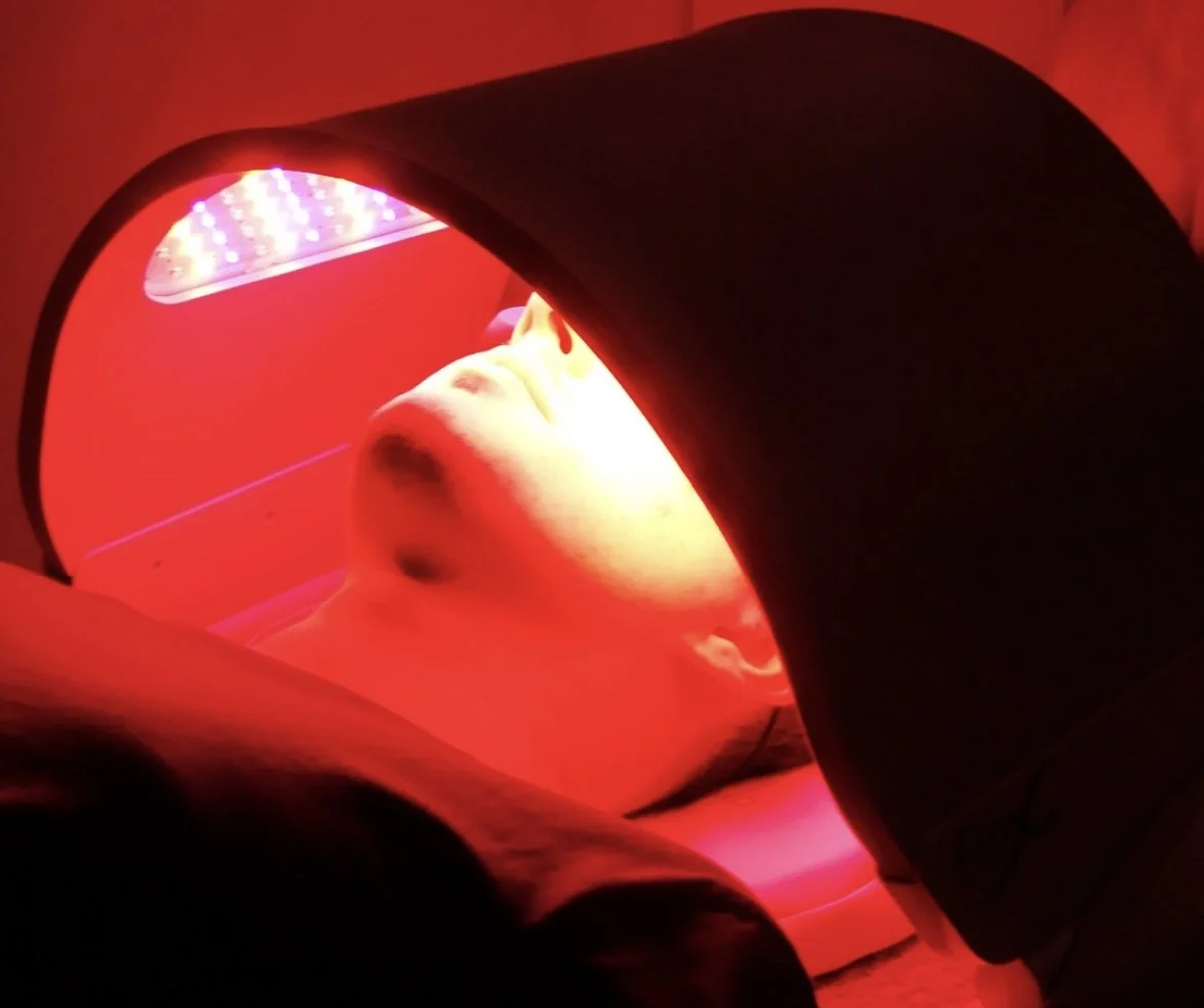 Person undergoing red light therapy with LED device