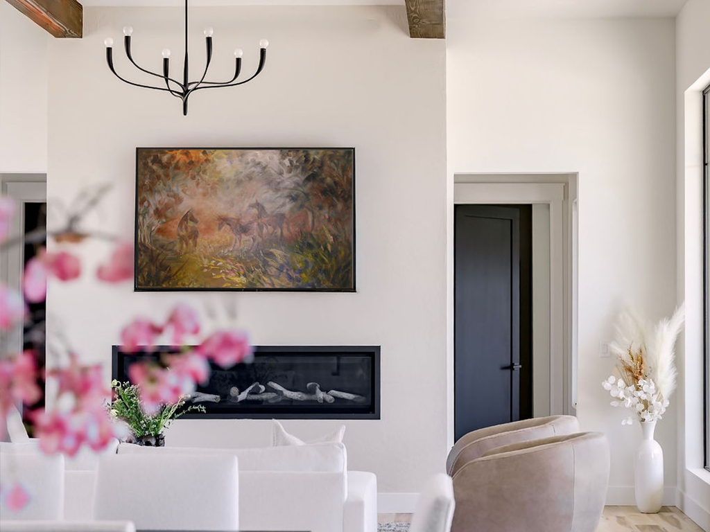 Scandanavian simple living room with white walls, horse painting, and flowers in the foreground