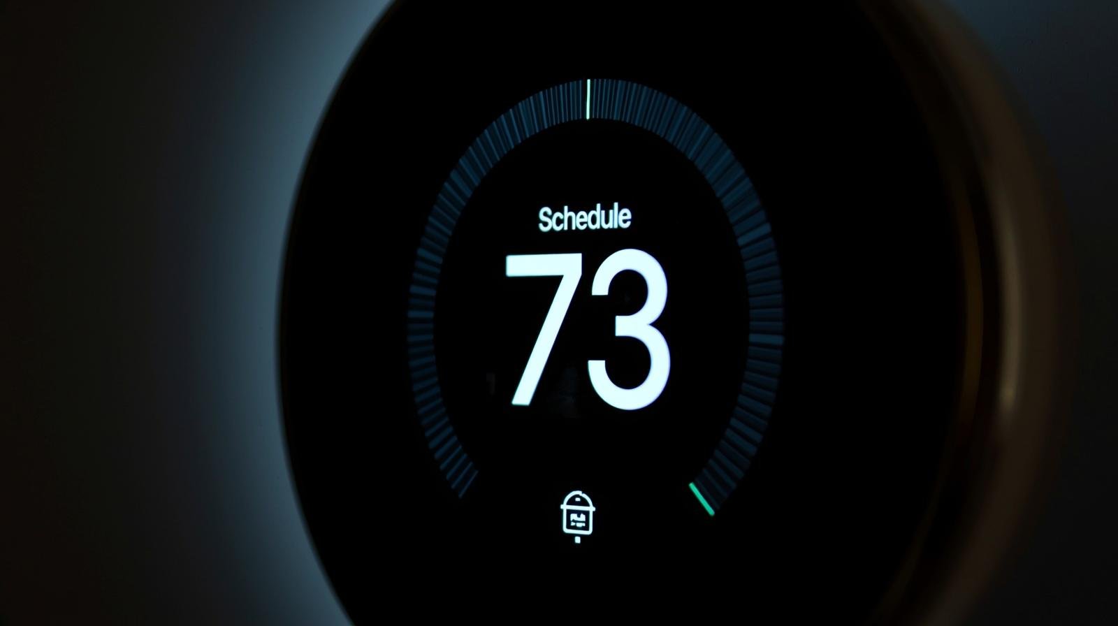 programmable smart thermostat showing 73-degree scheduled temperature for energy-efficient heat pump control in California home