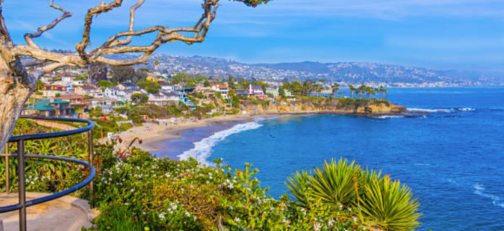 aerial coastal view of an Orange County beach neighborhood with homes along the bluffs, representing the varied climate zones J Martin IAQ services for summer AC preparation