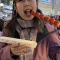 woman eating shish kabob and wearing a gray scarf