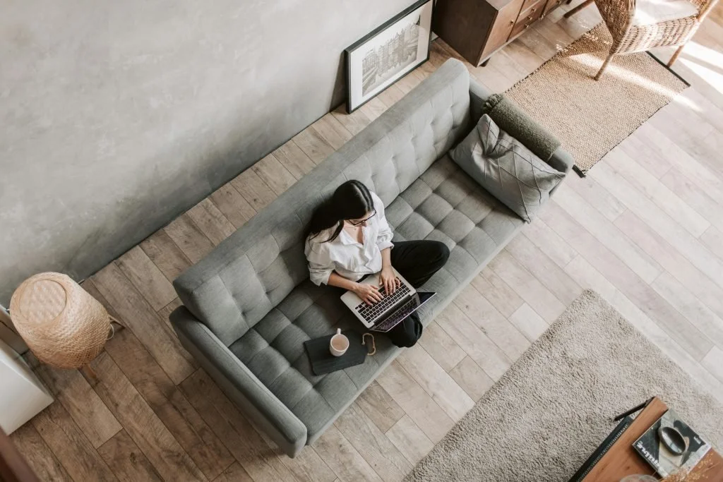 woman relaxing on couch in comfortable home with energy efficient cooling and good indoor airflow