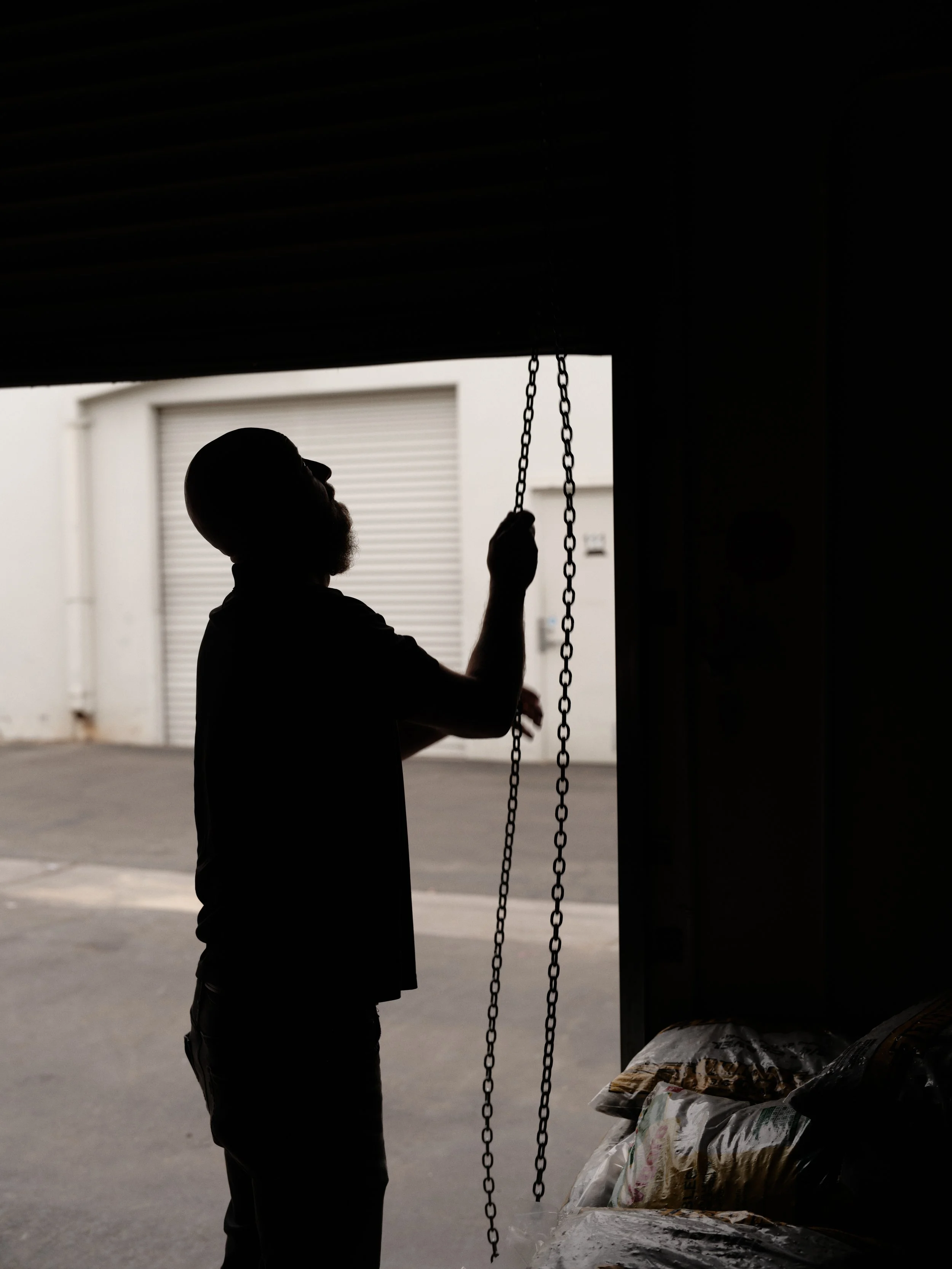 silhouette of HVAC technician inspecting air conditioning system components at commercial property in Orange County