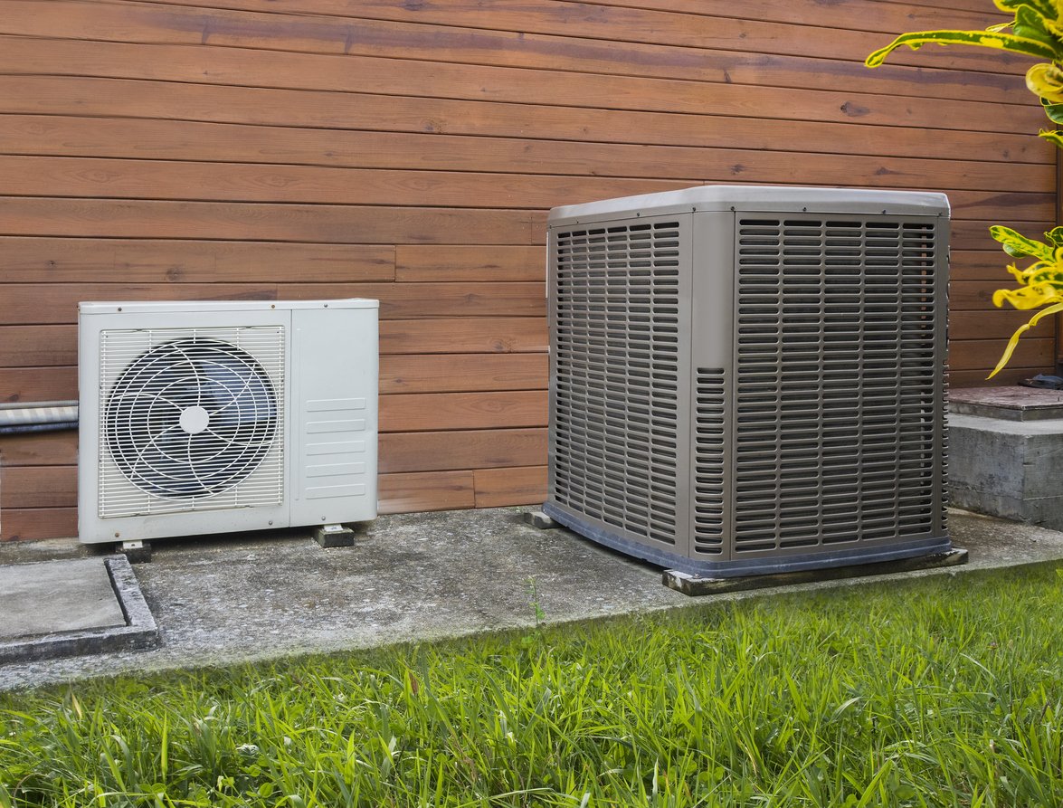Residential outdoor air conditioning condenser units installed beside a home