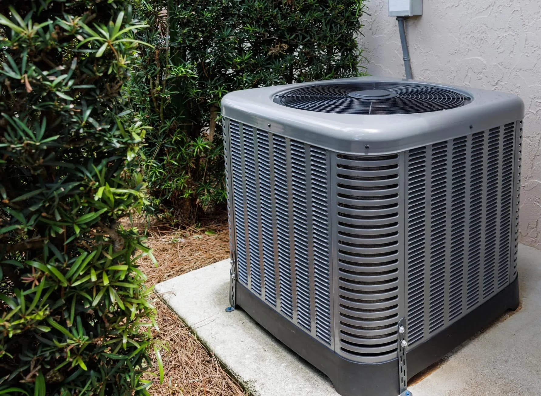Outdoor HVAC condenser unit installed beside a Brea, CA home surrounded by landscaping