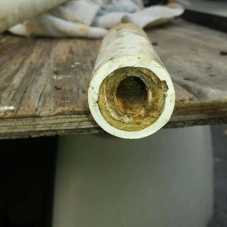 Inside of clogged AC condensate drain pipe with sludge and algae buildup