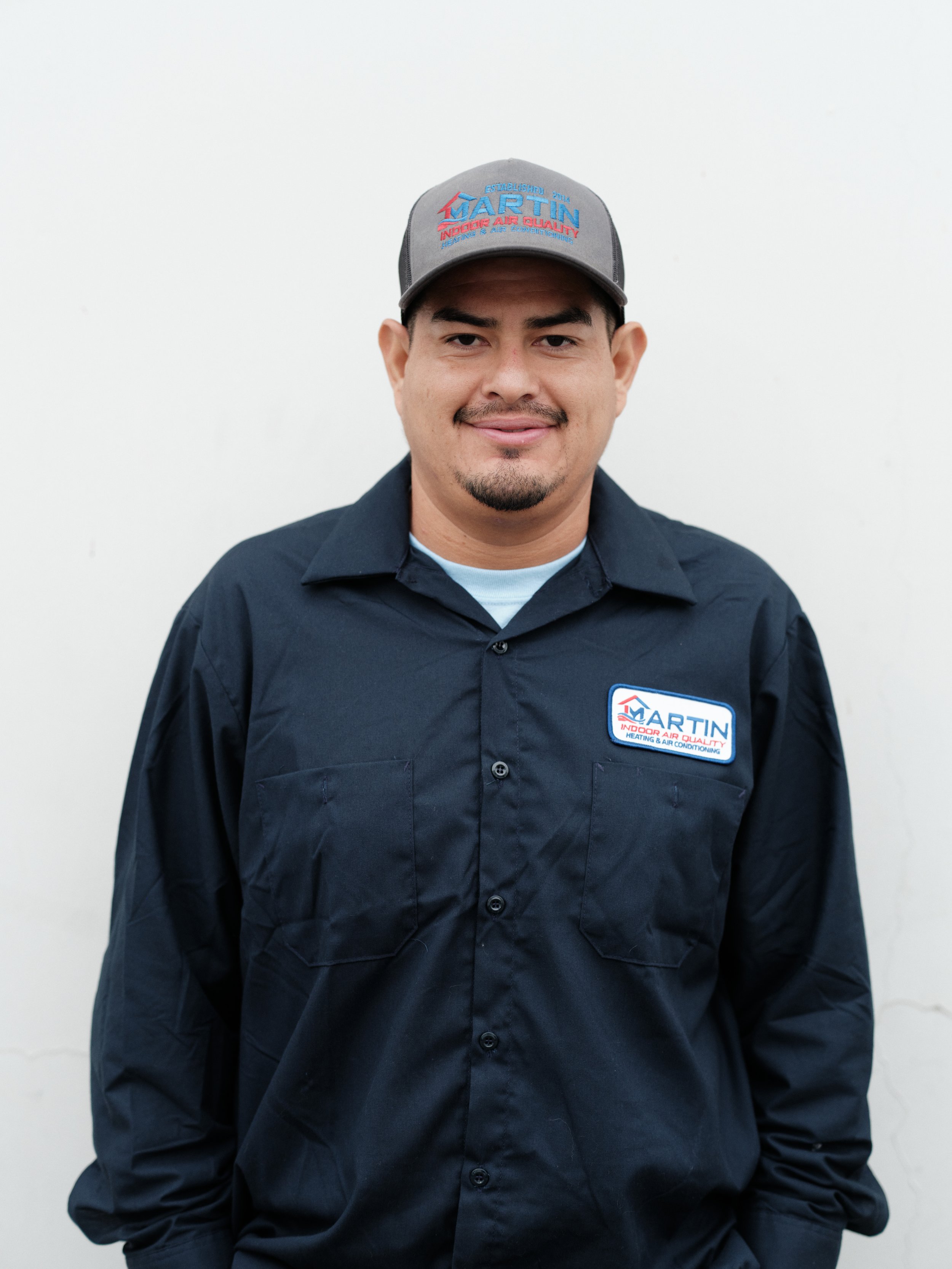J Martin Indoor Air Quality HVAC technician in branded uniform and cap serving Orange County homeowners with honest heating and air conditioning service