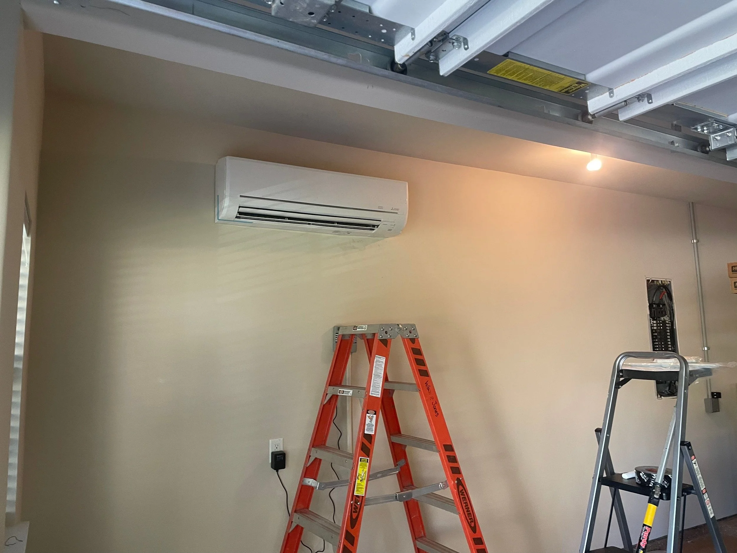Mitsubishi mini split indoor wall unit installed in a garage conversion during active installation