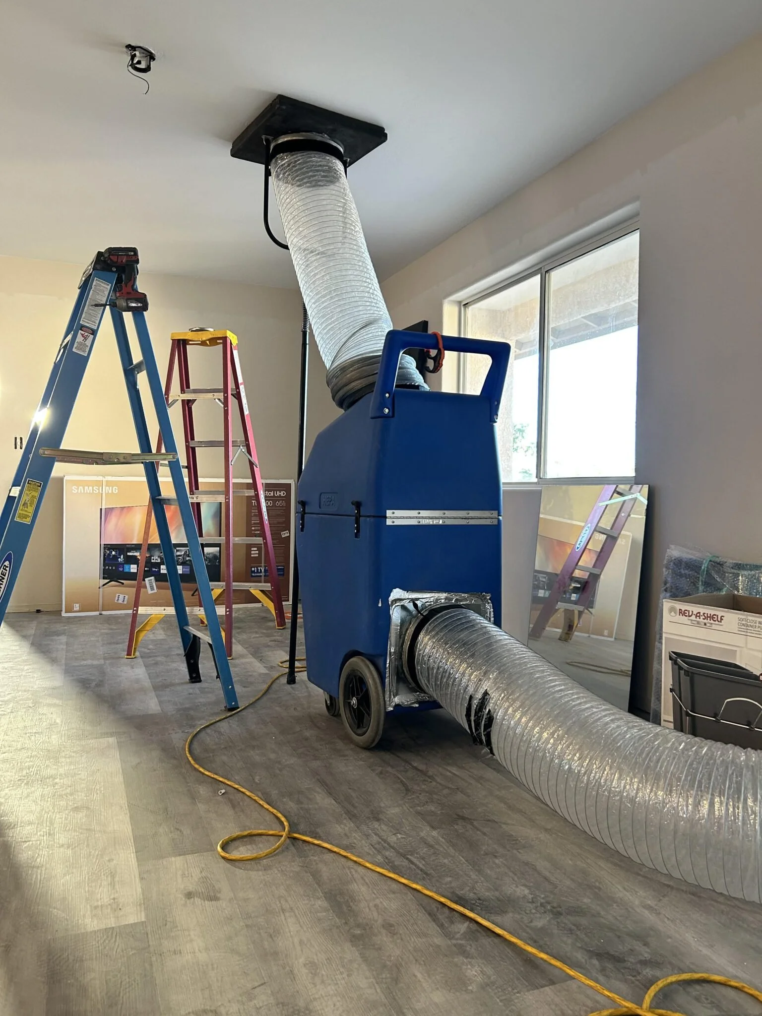 professional air duct cleaning equipment with negative air machine connected to ceiling duct in an Orange County home