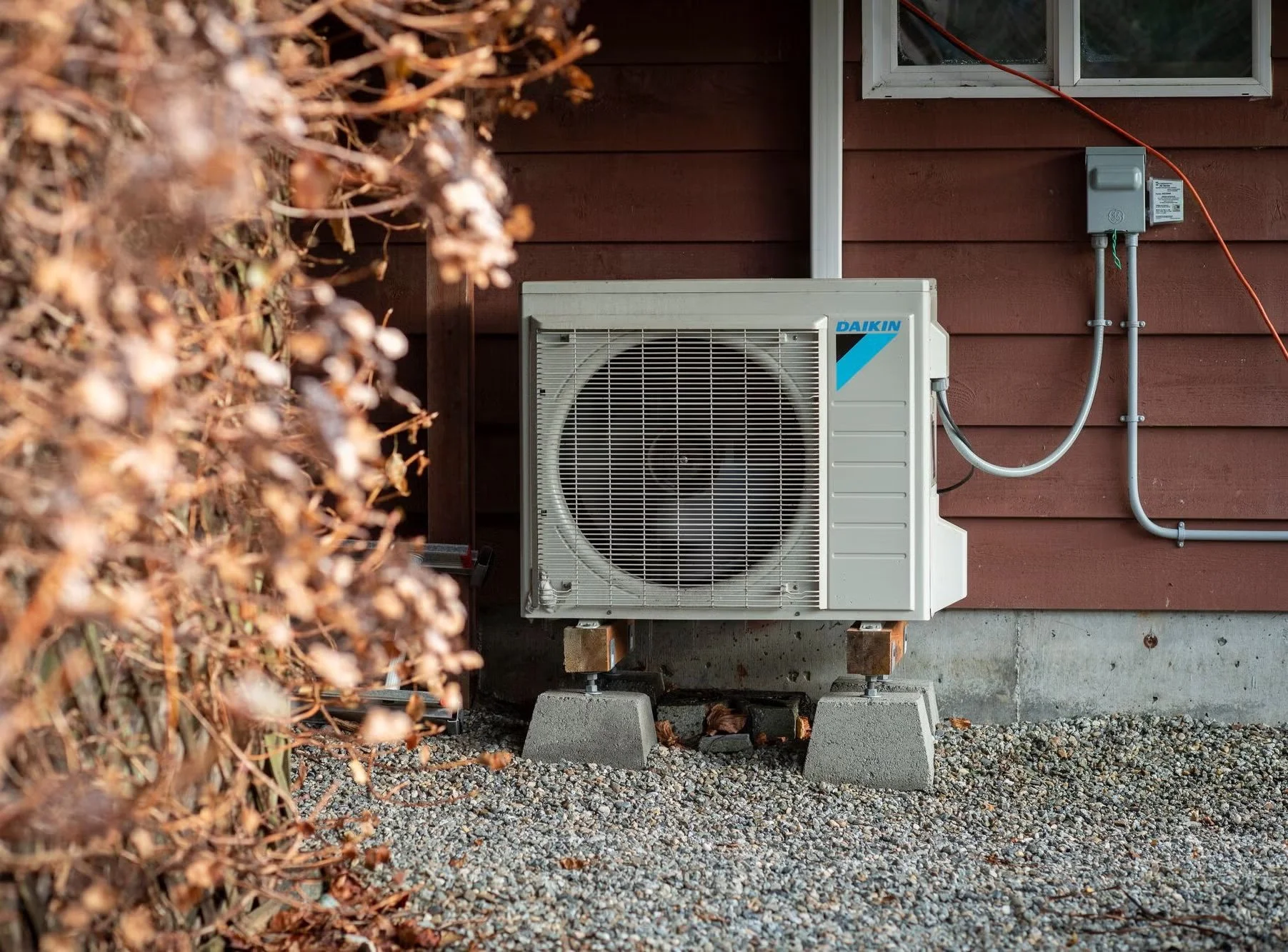 Daikin heat pump outdoor unit installed on home exterior in cold winter climate