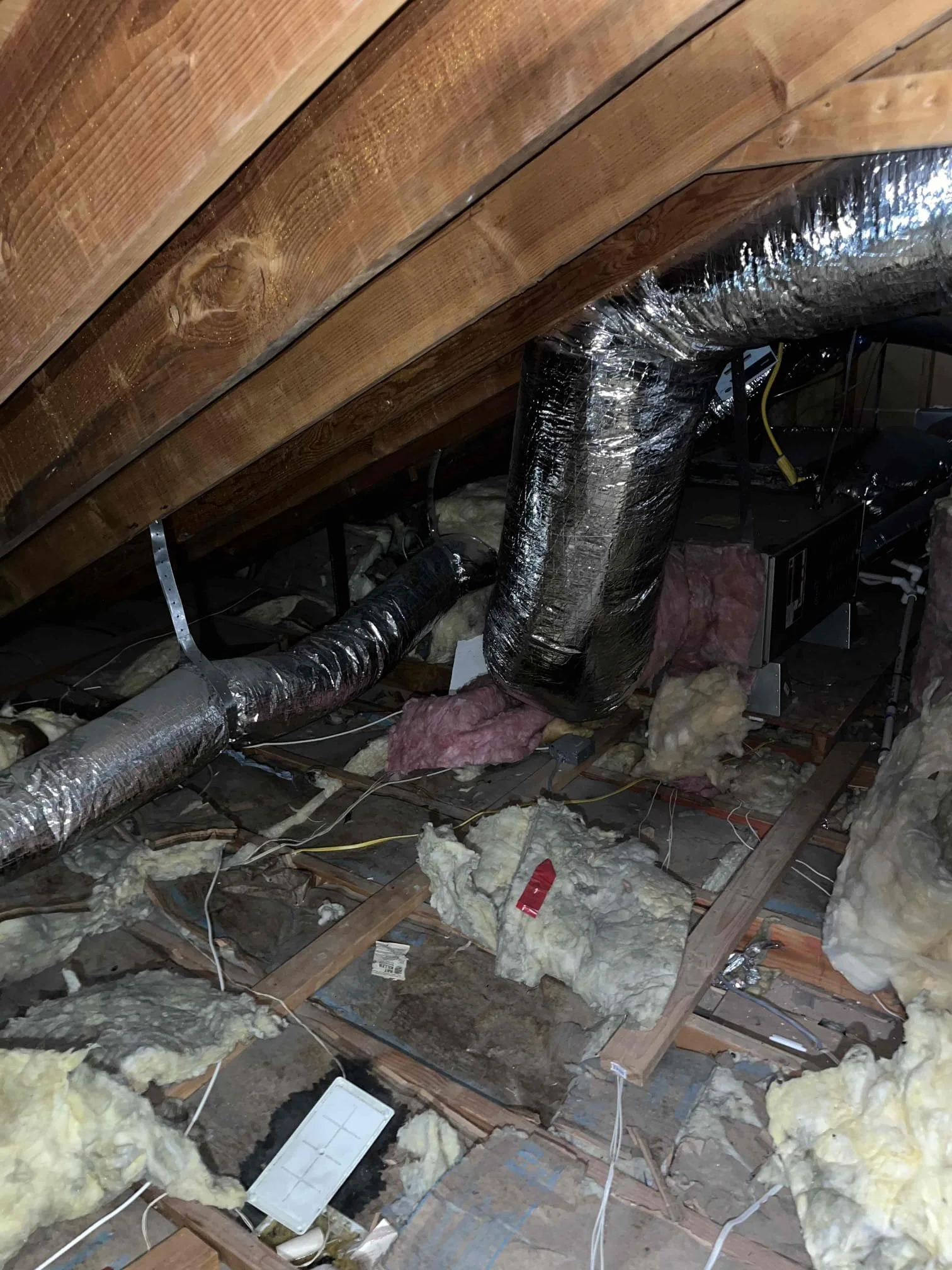 insufficient attic insulation in Orange County home showing exposed ceiling joists and compressed R-19 insulation