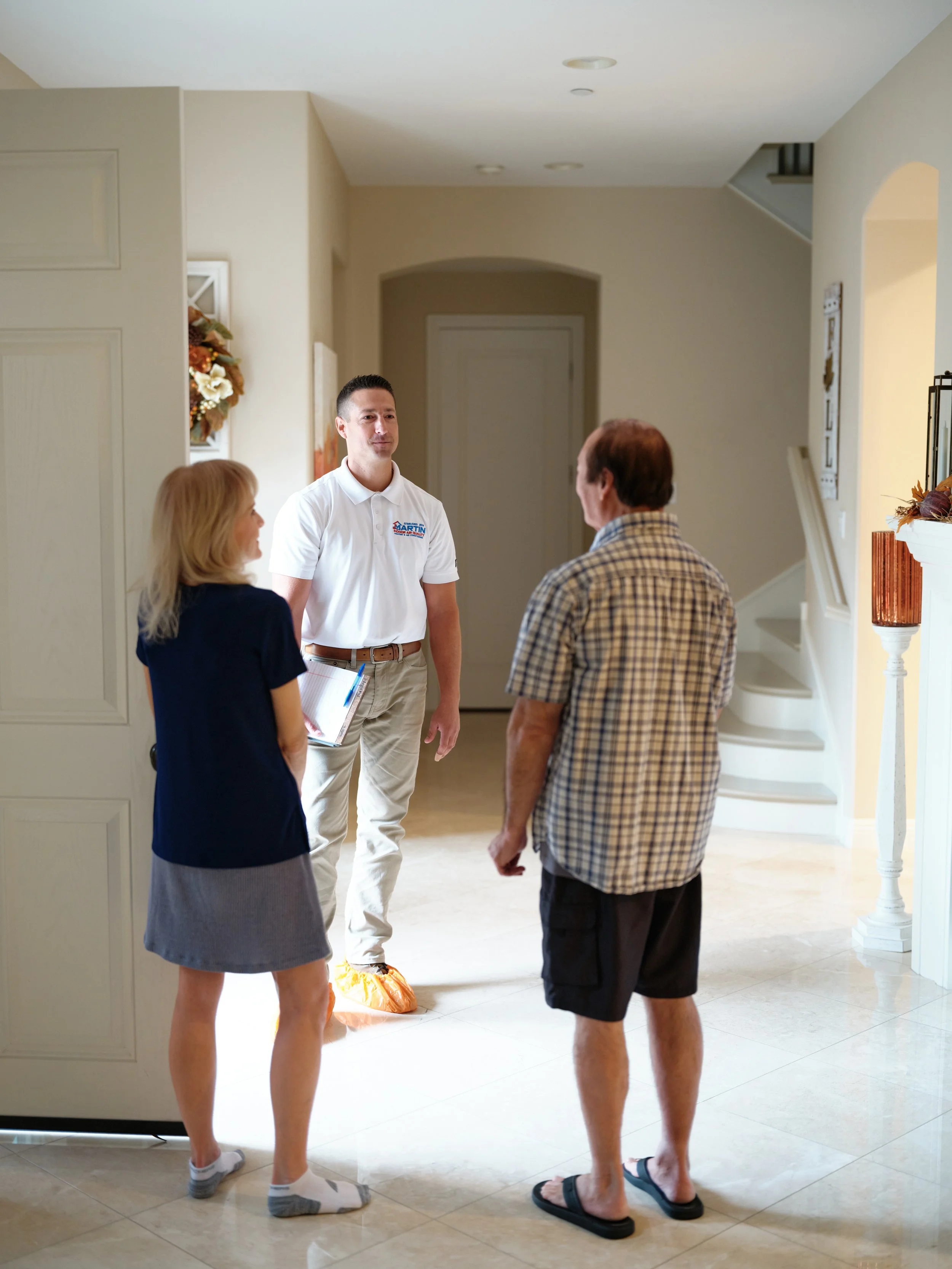 J Martin HVAC technician consulting with homeowners about air duct cleaning inspection