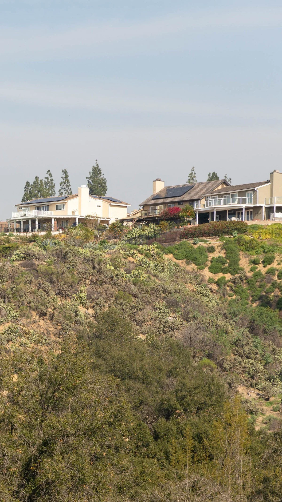 Hillside homes with solar panels in Anaheim Hills, California overlooking foothill terrain