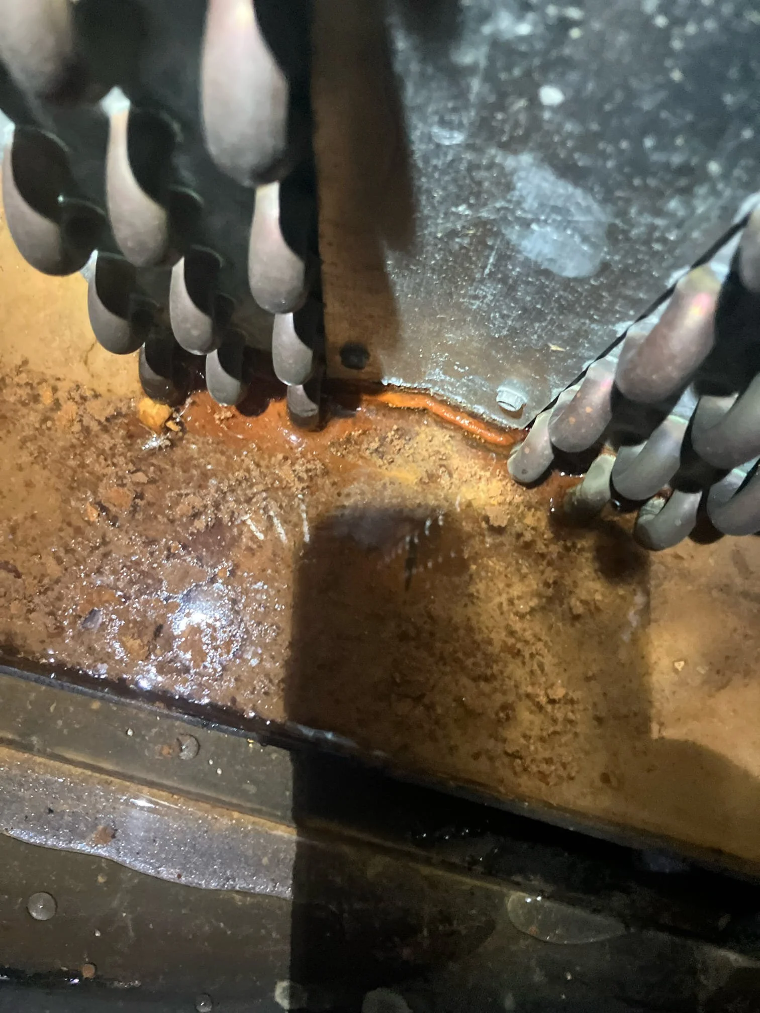 Corroded AC evaporator coil with heavy rust buildup and refrigerant leak damage requiring coil replacement Orange County HVAC repair