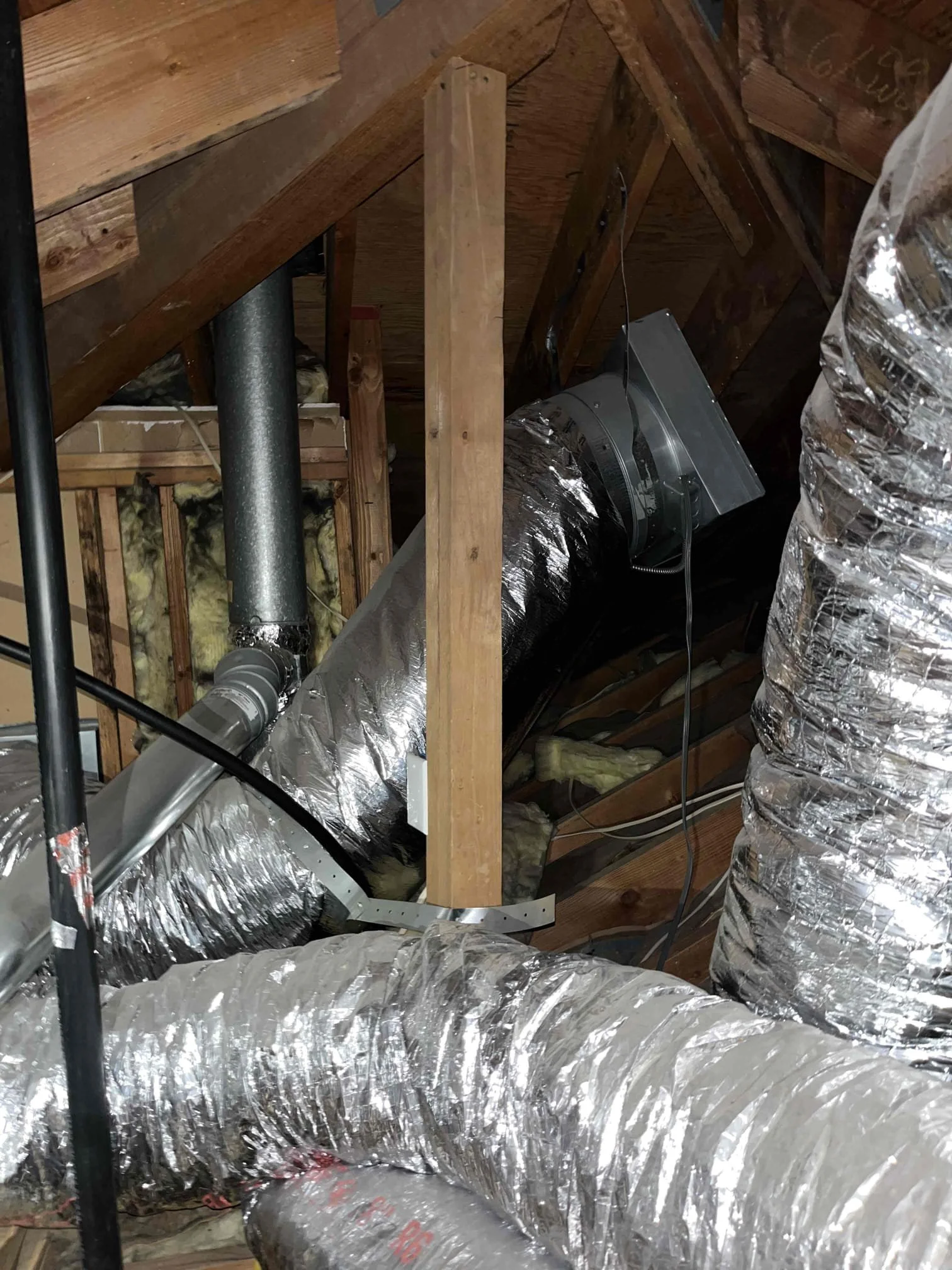 attic HVAC ductwork with insulated flex ducts and ventilation system for residential airflow