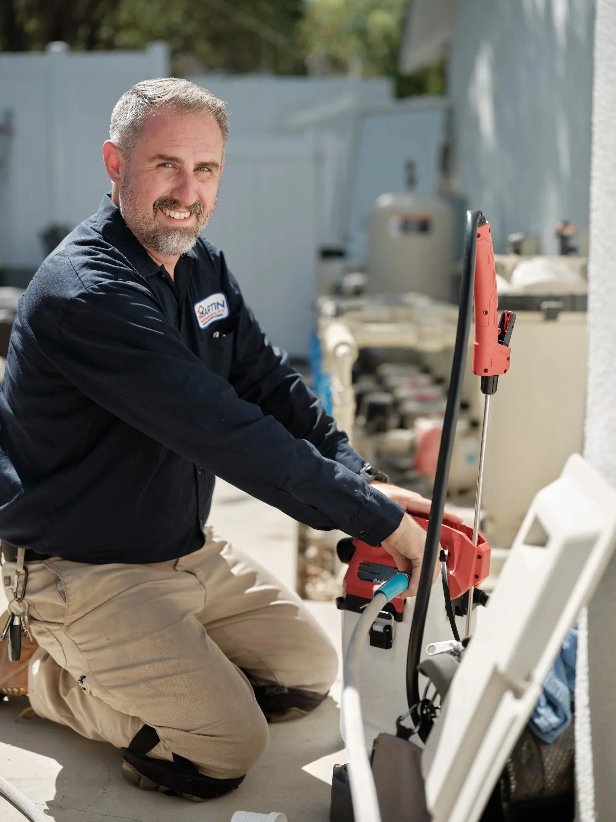J Martin HVAC technician servicing an AC condenser unit in Yorba Linda