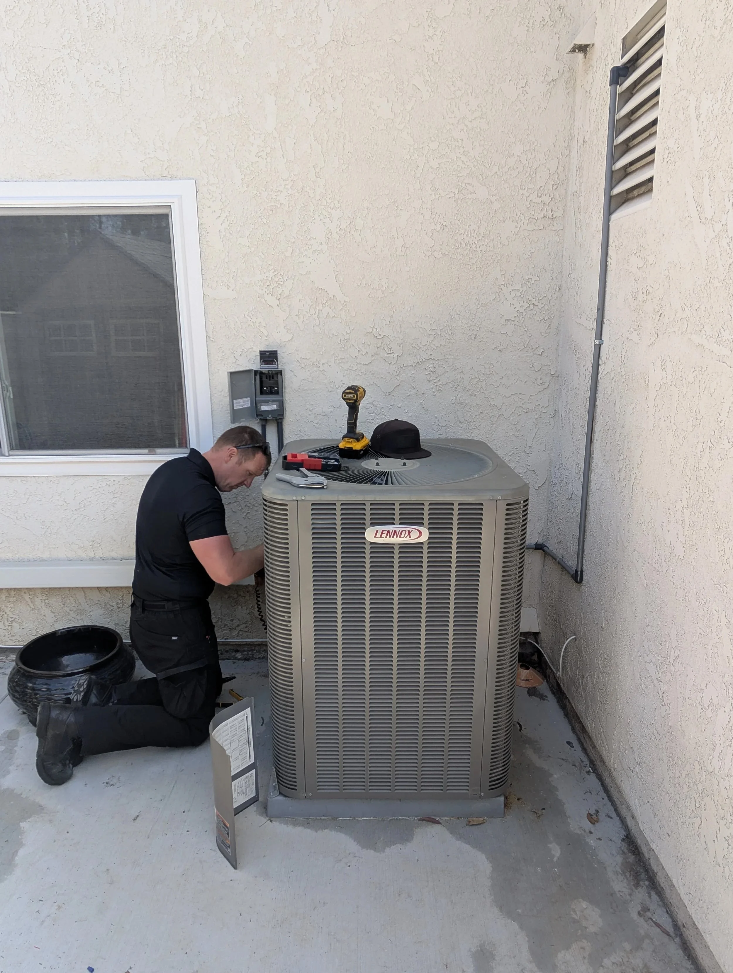 HVAC technician holding refrigerant line tools in front of J Martin Indoor Air service van in Brea, CA
