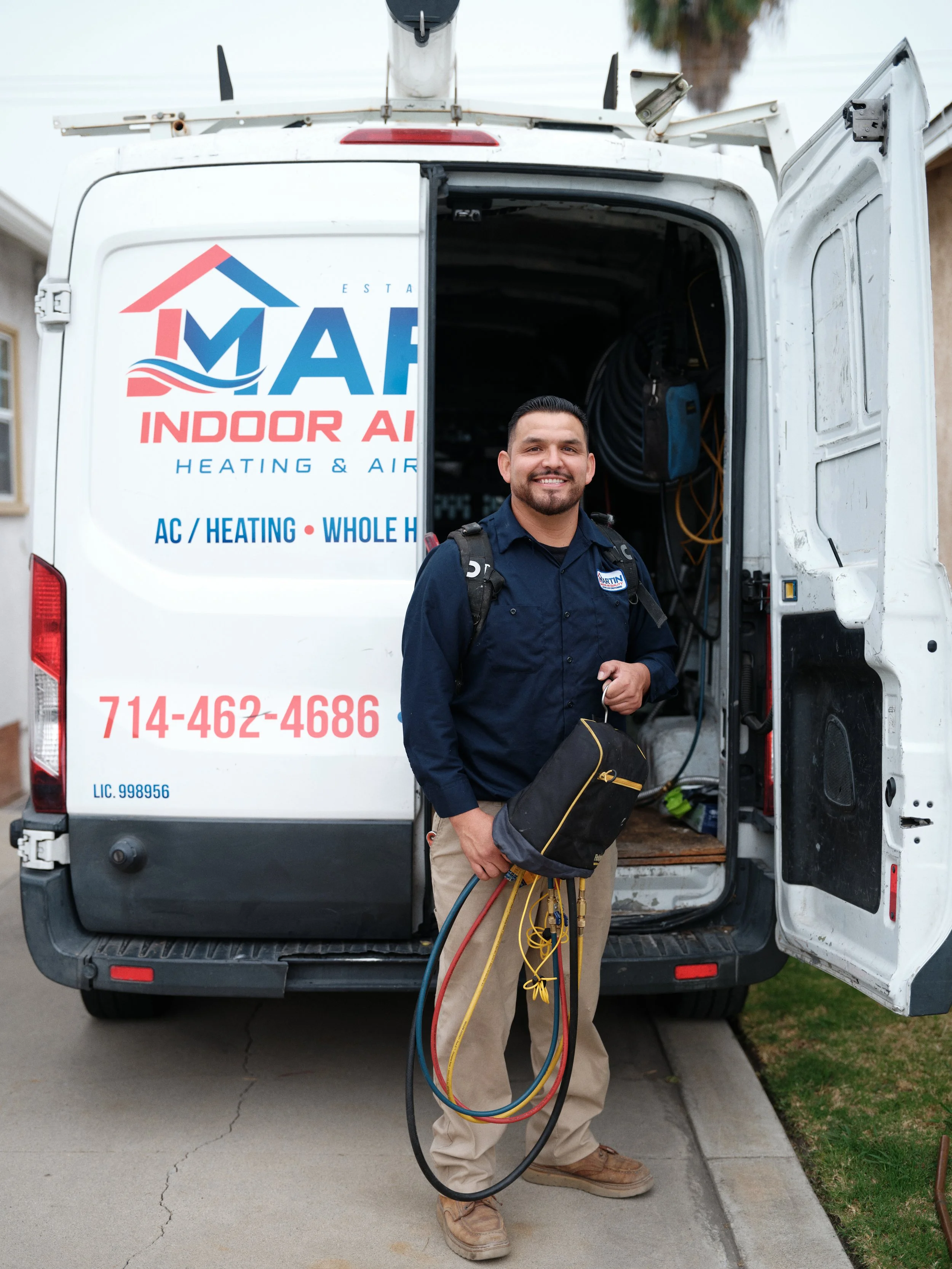 licensed HVAC technician from J Martin Indoor Air Quality standing by service van with tools for heat pump installation in Yorba Linda