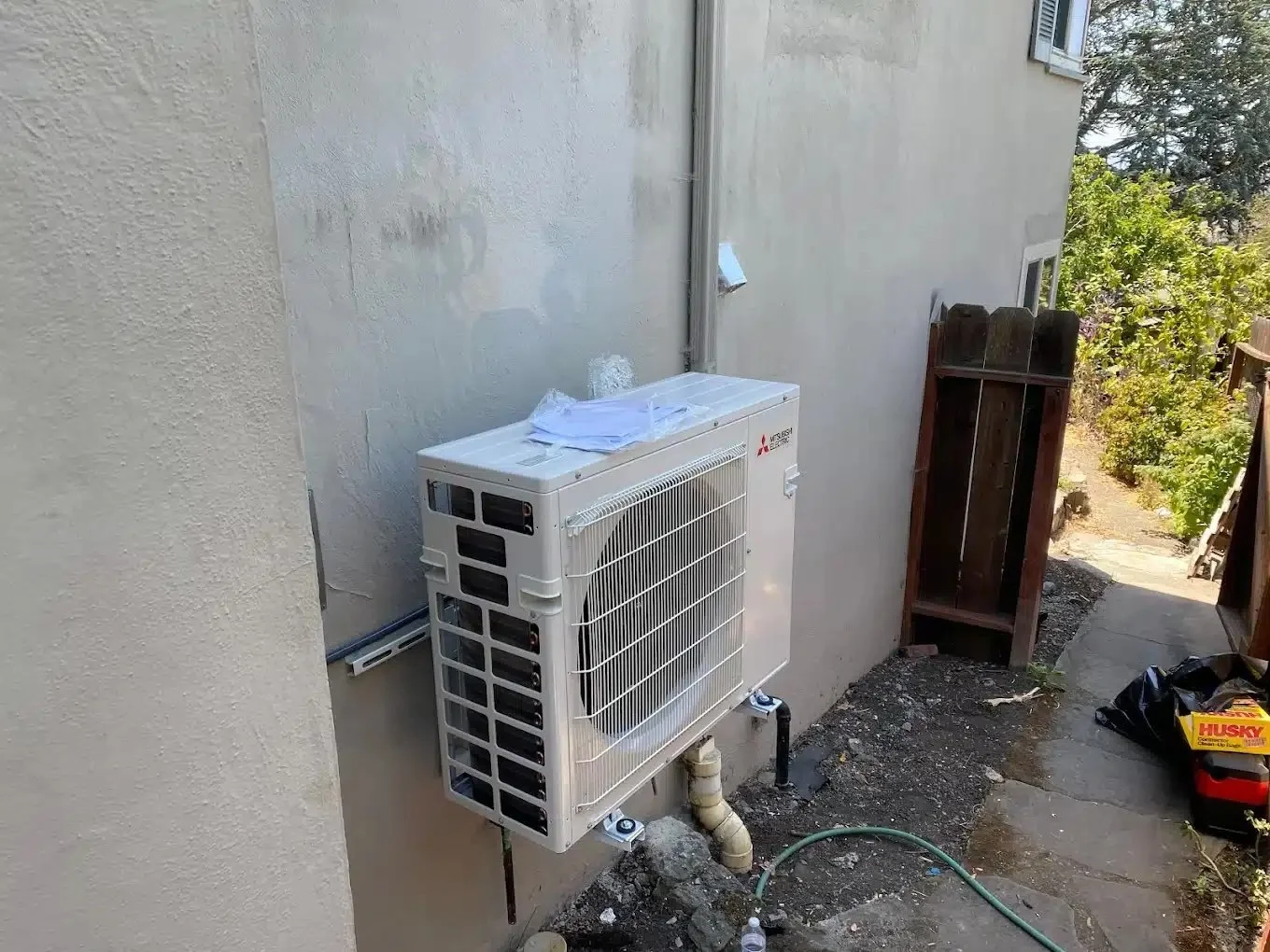 Mitsubishi H2i heat pump outdoor unit installed on exterior wall of Anaheim Hills home