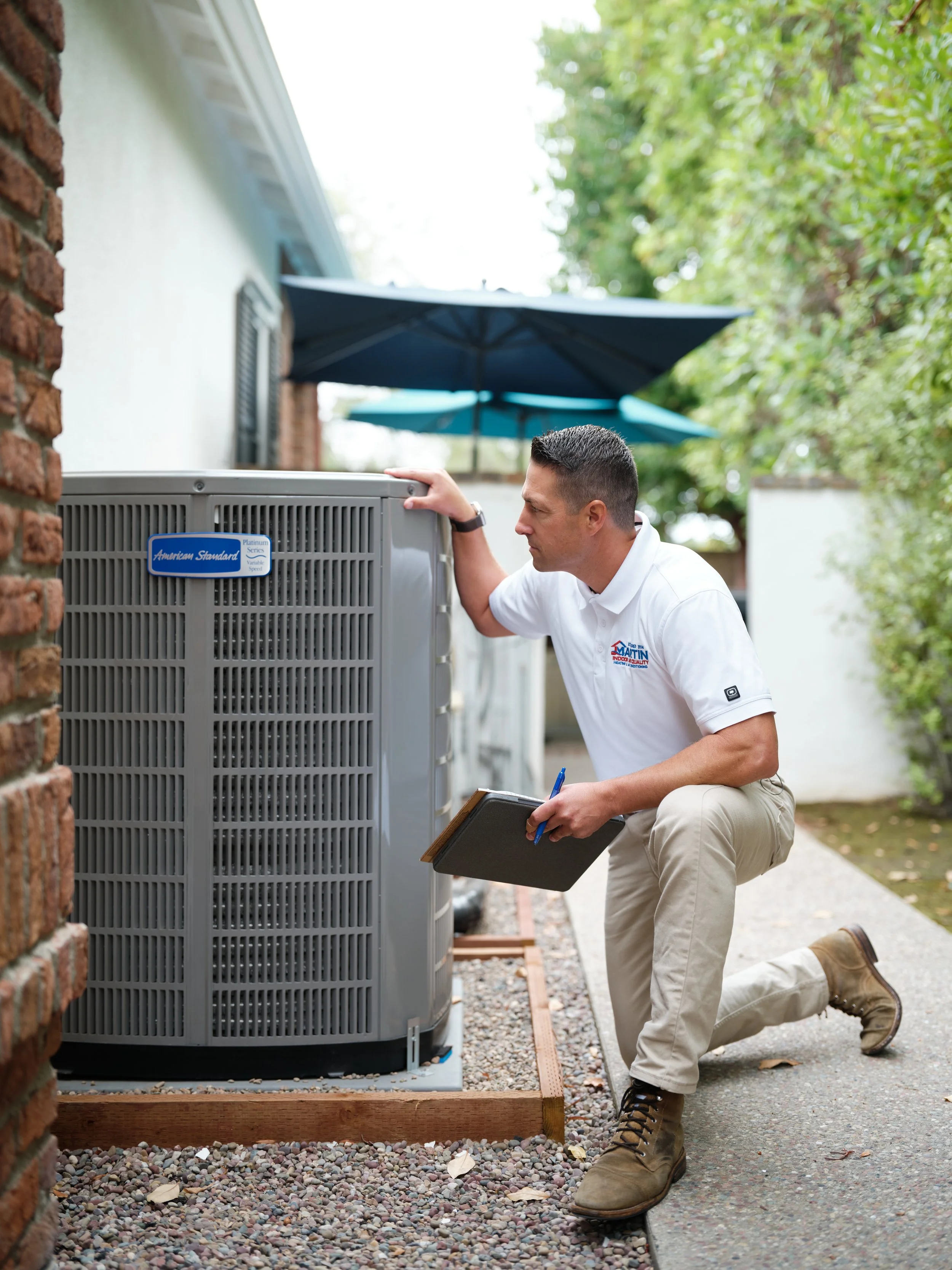 J Martin HVAC technician performing professional assessment of American Standard air conditioning system to evaluate repair versus replacement during R-410A phase-out