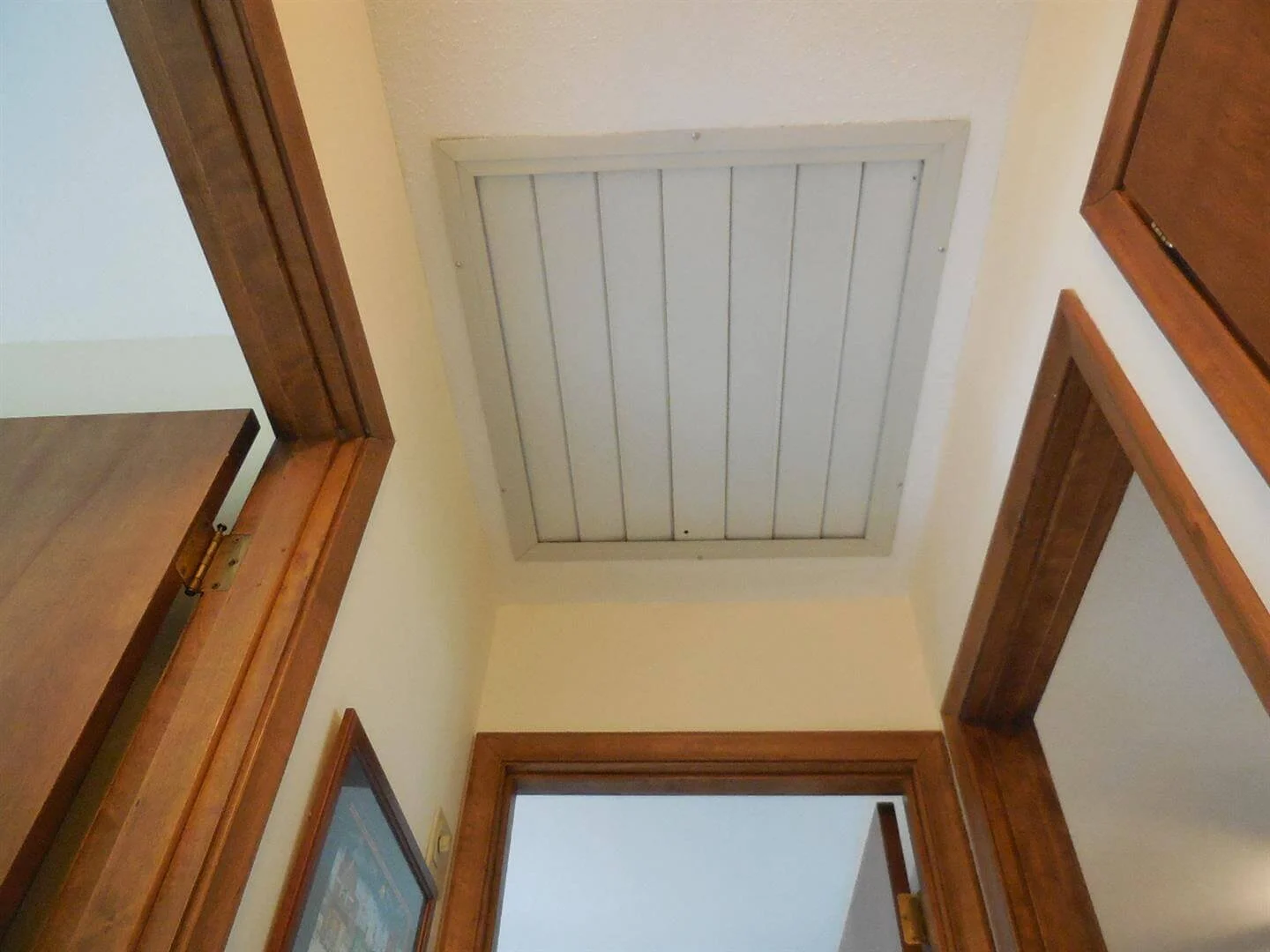 ceiling-mounted whole house fan grille installed in hallway for home ventilation