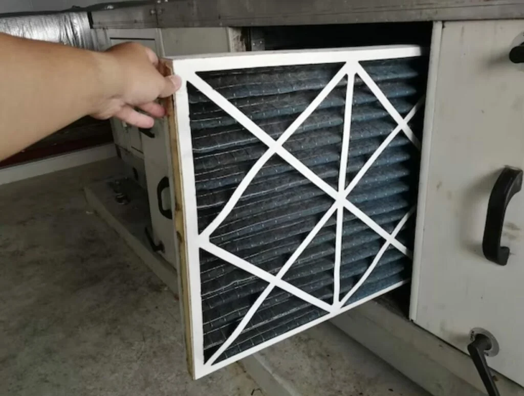 Homeowner installing a new HVAC air filter inside residential heating and cooling system