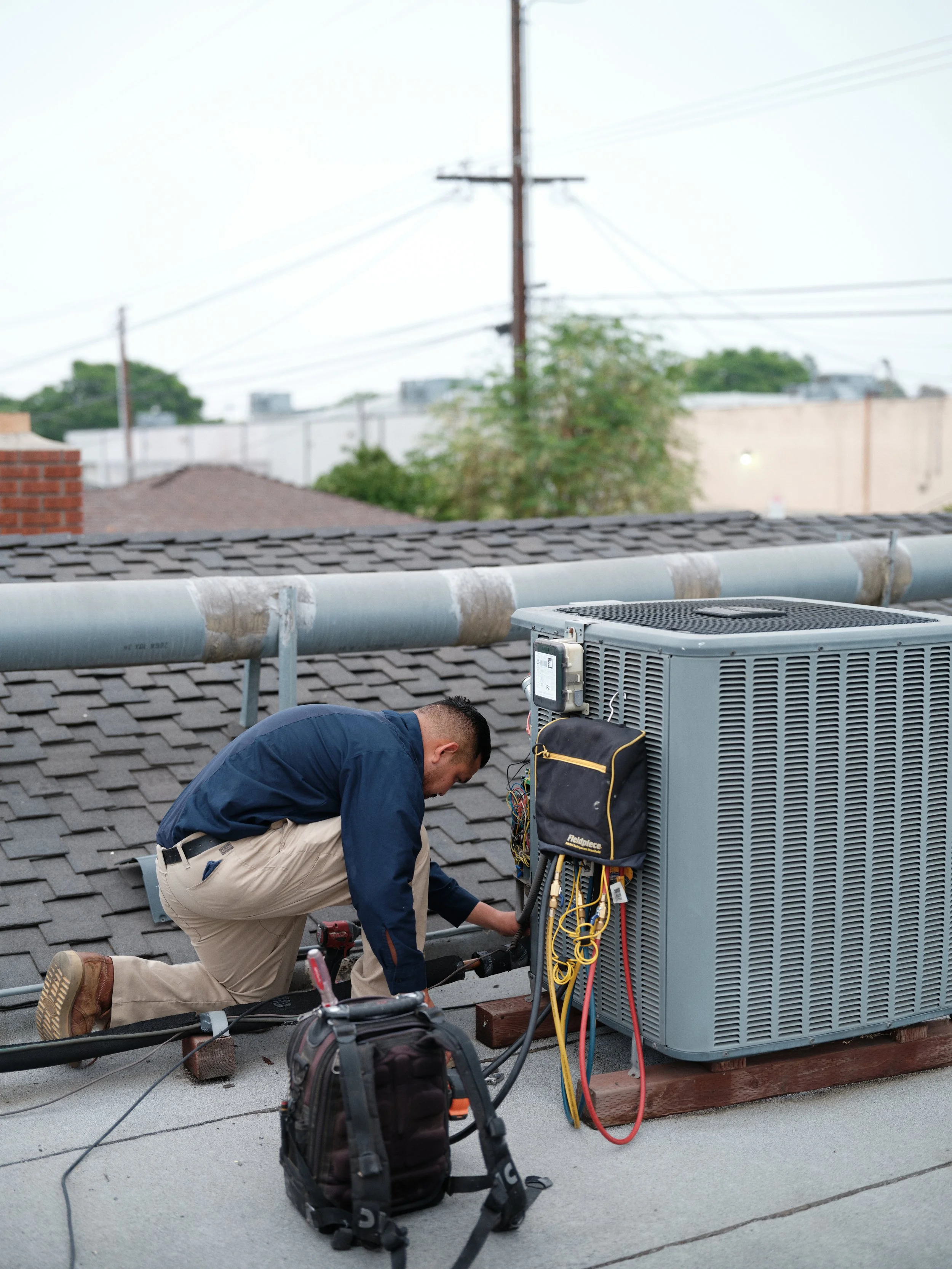 HVAC technician servicing R-410A air conditioner on Orange County rooftop