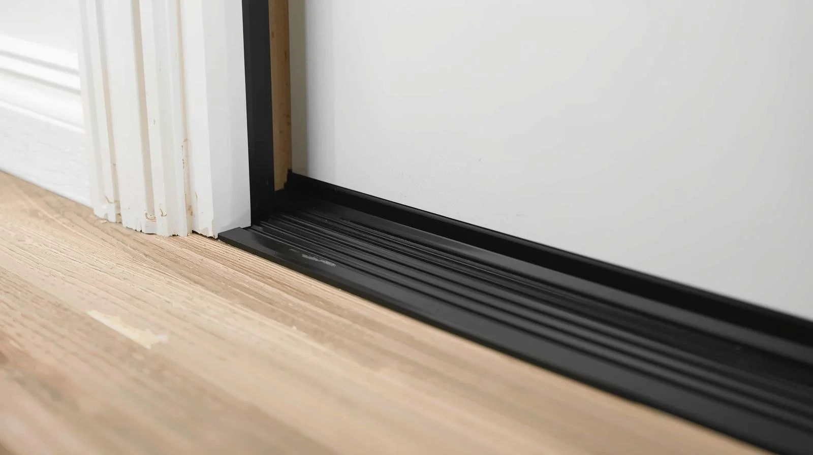 Door sweep installed at bottom of exterior door to prevent heat loss and air leaks