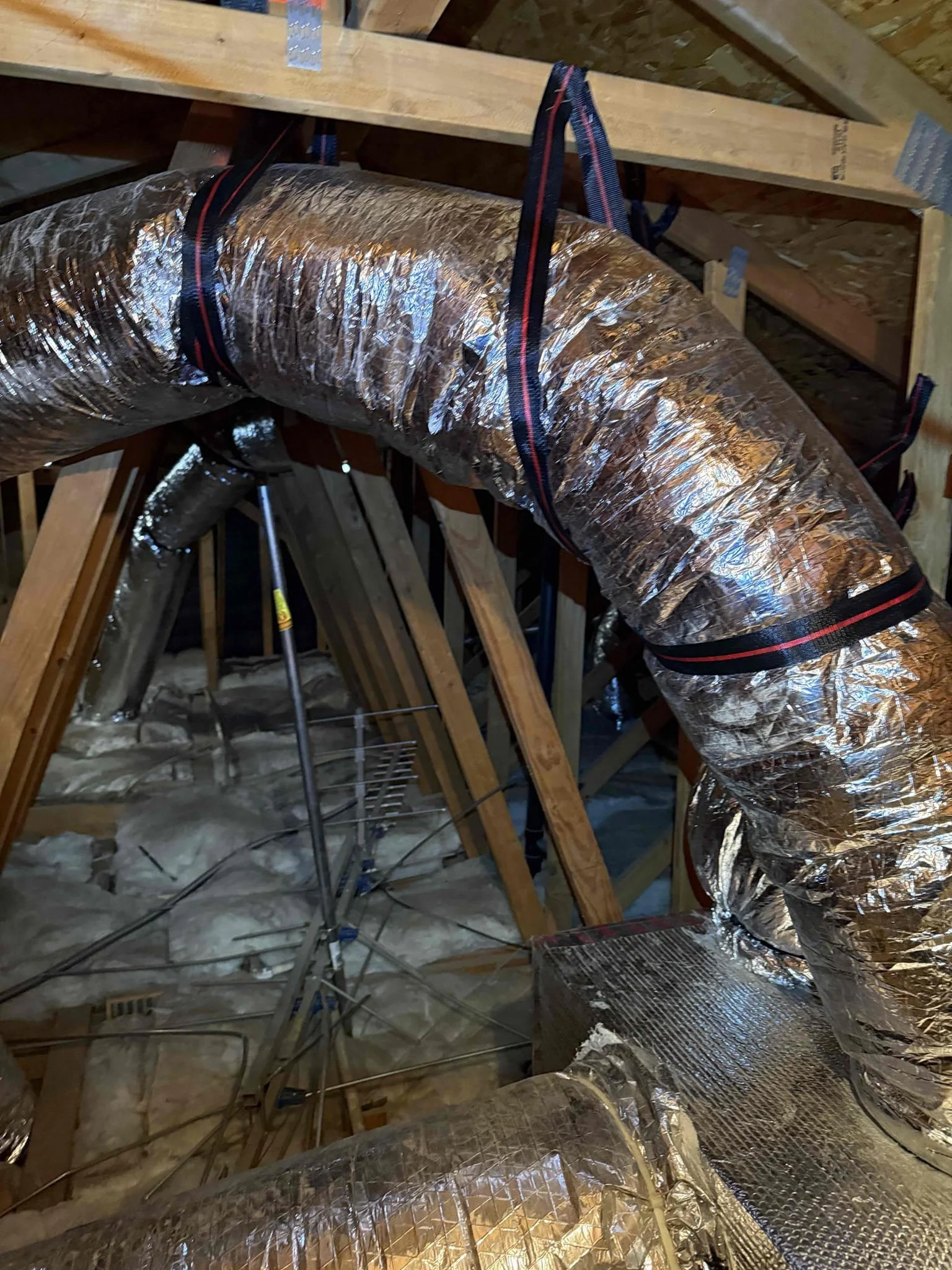 Insulated attic ductwork in an Orange County home where leaks and poor connections can cause uneven room temperatures
