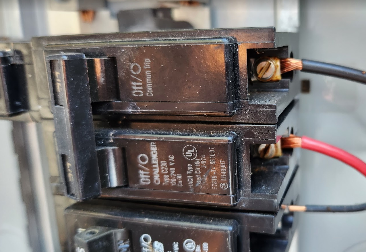 Close-up of a circuit breaker with a loose wire connection inside an electrical panel