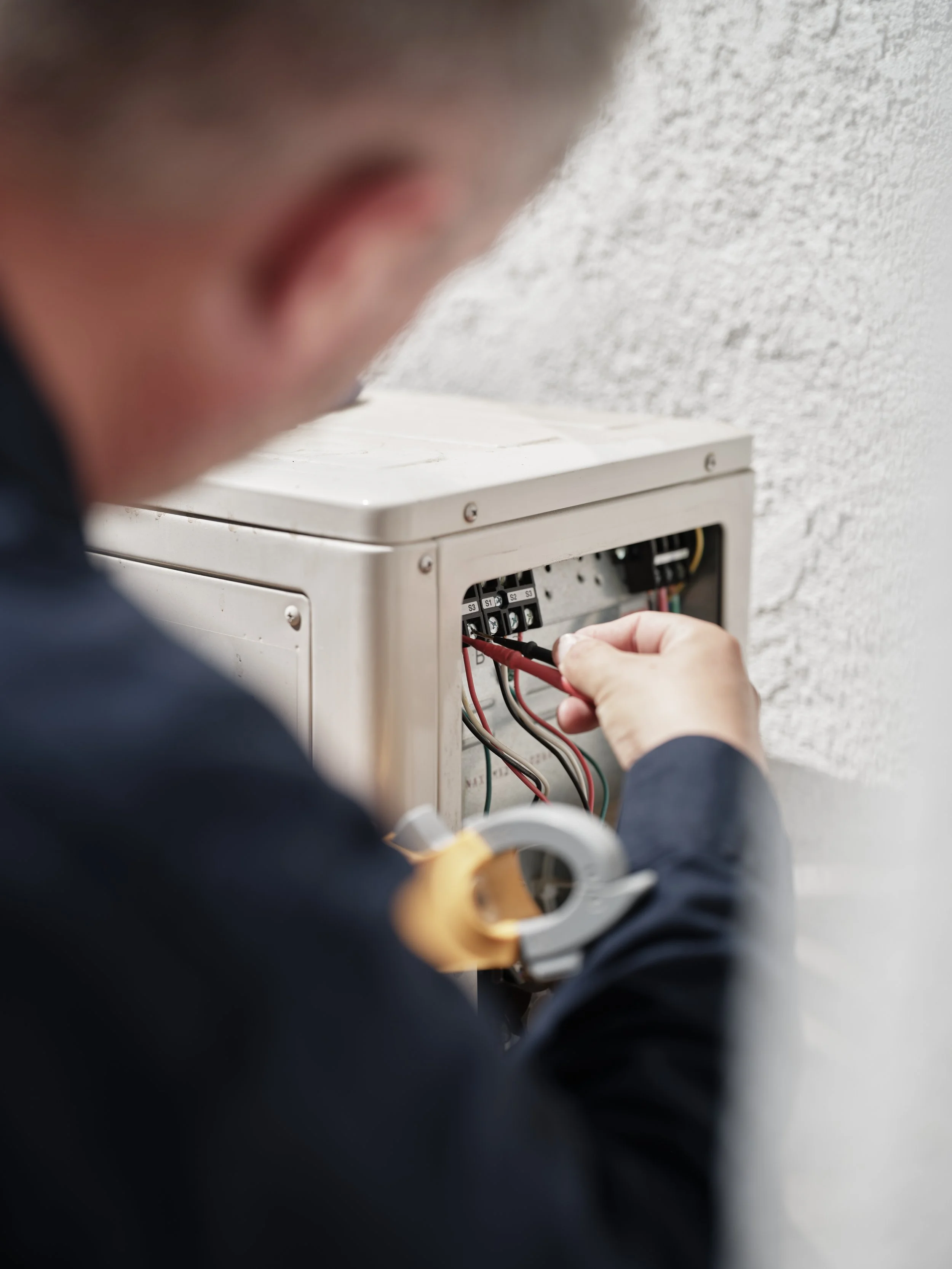 HVAC technician troubleshooting electrical disconnect panel during air conditioner repair service unaffected by R-410A phase-out