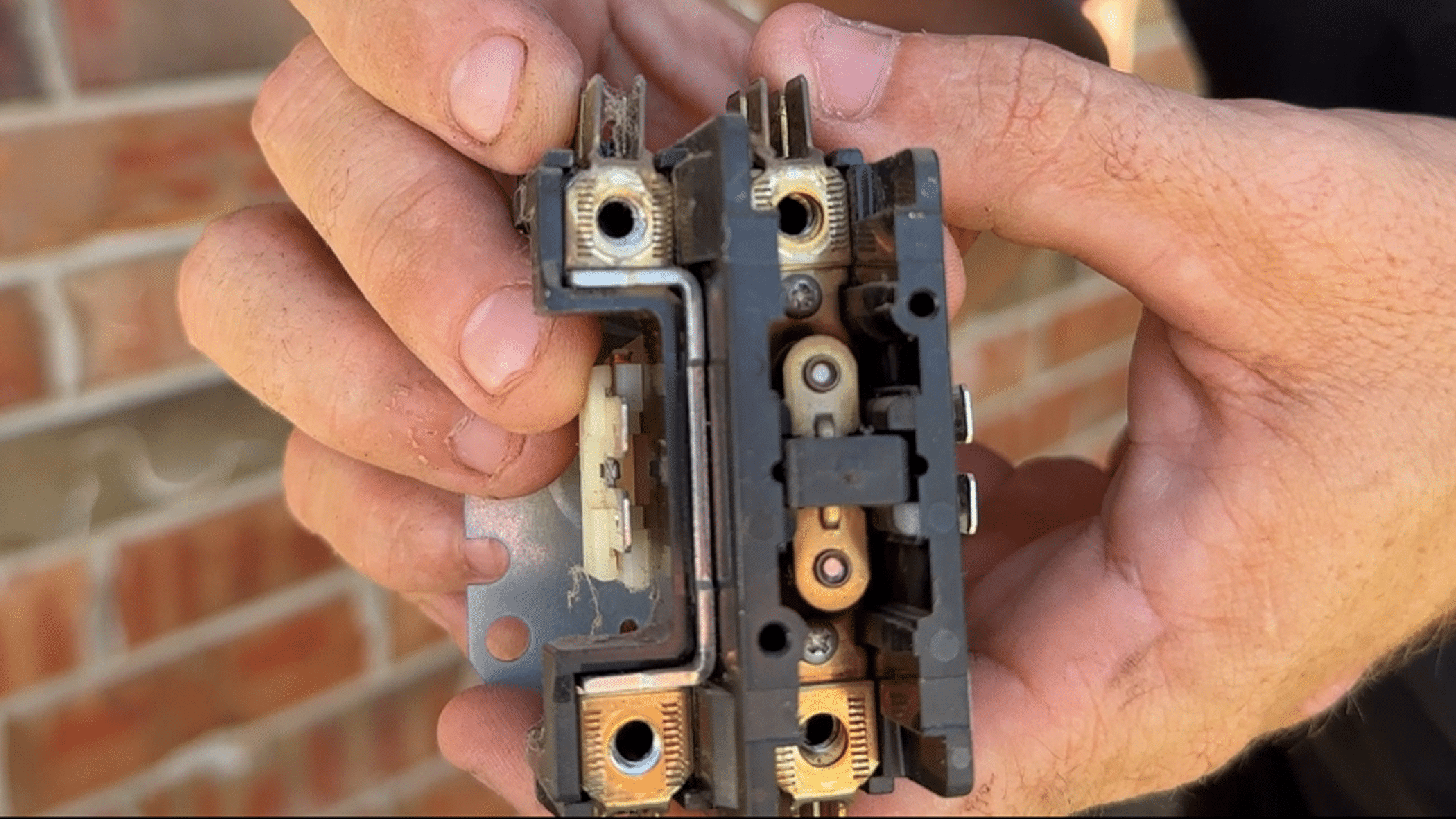 Worn AC contactor with burned electrical terminals that can cause an air conditioner to trip the breaker