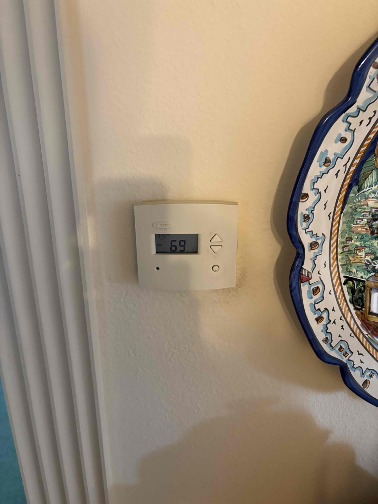 digital thermostat displaying temperature setting on wall in home with AC short cycling problem