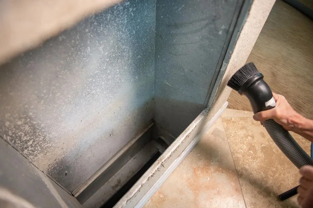 vacuum removing dust buildup inside residential HVAC air duct during professional air duct cleaning service