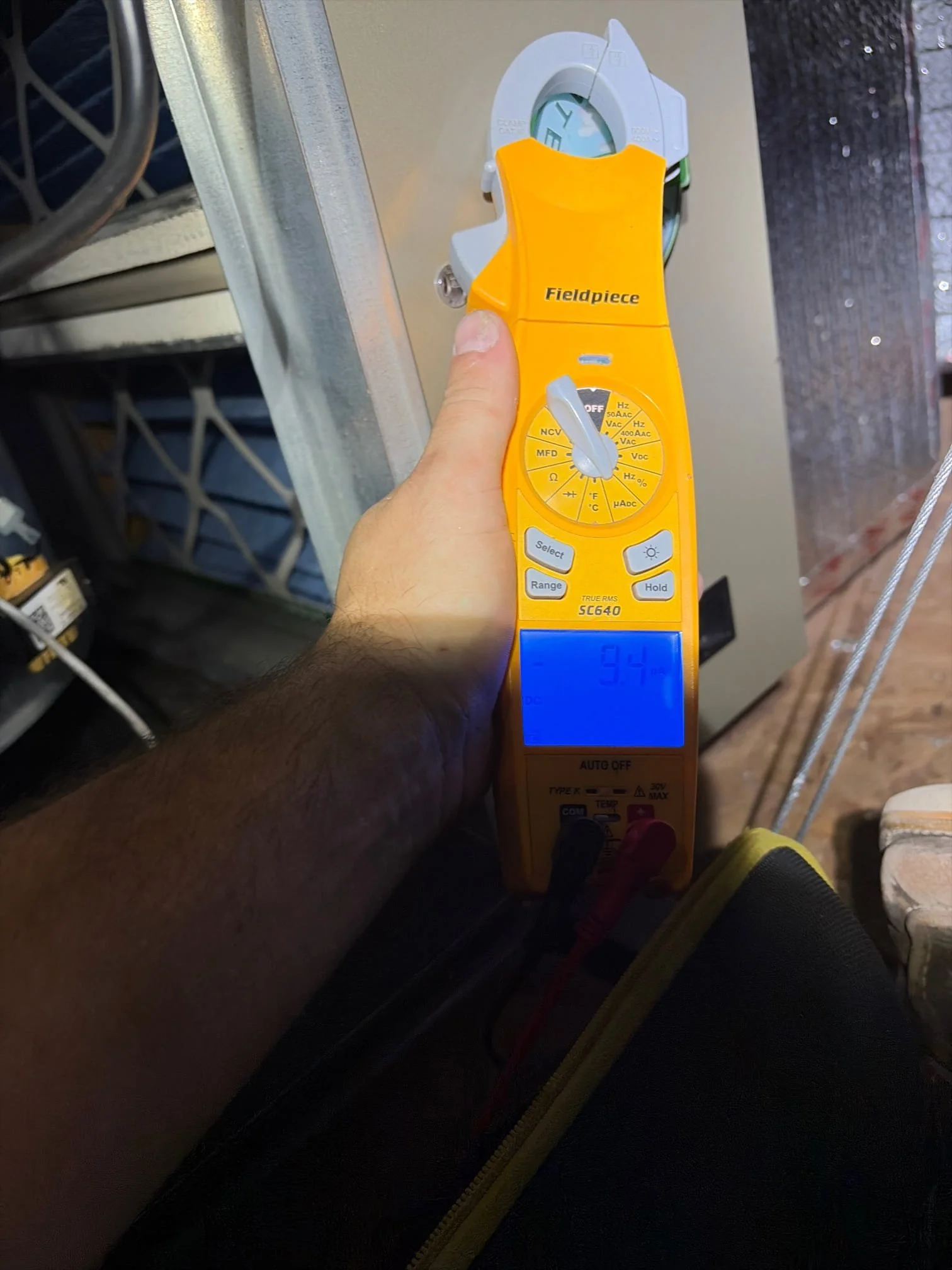 J Martin HVAC technician using a diagnostic meter to evaluate AC system performance in an Anaheim Hills home