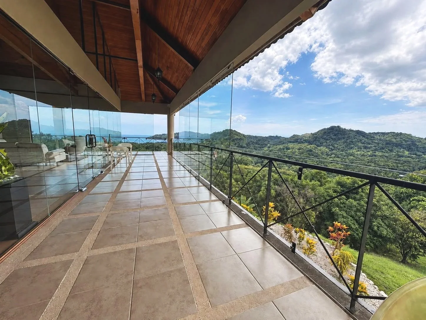 Panoramic outdoor terrace beside the glass-walled living room overlooking the Nicoya Peninsula