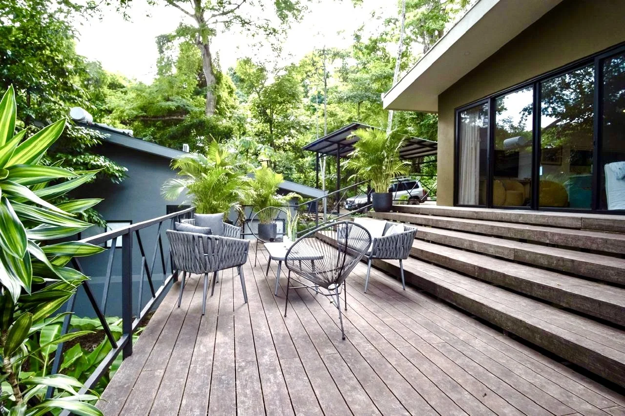 Spacious wooden outdoor terrace with seating and tropical garden views at House of Light in Paquera, Costa Rica