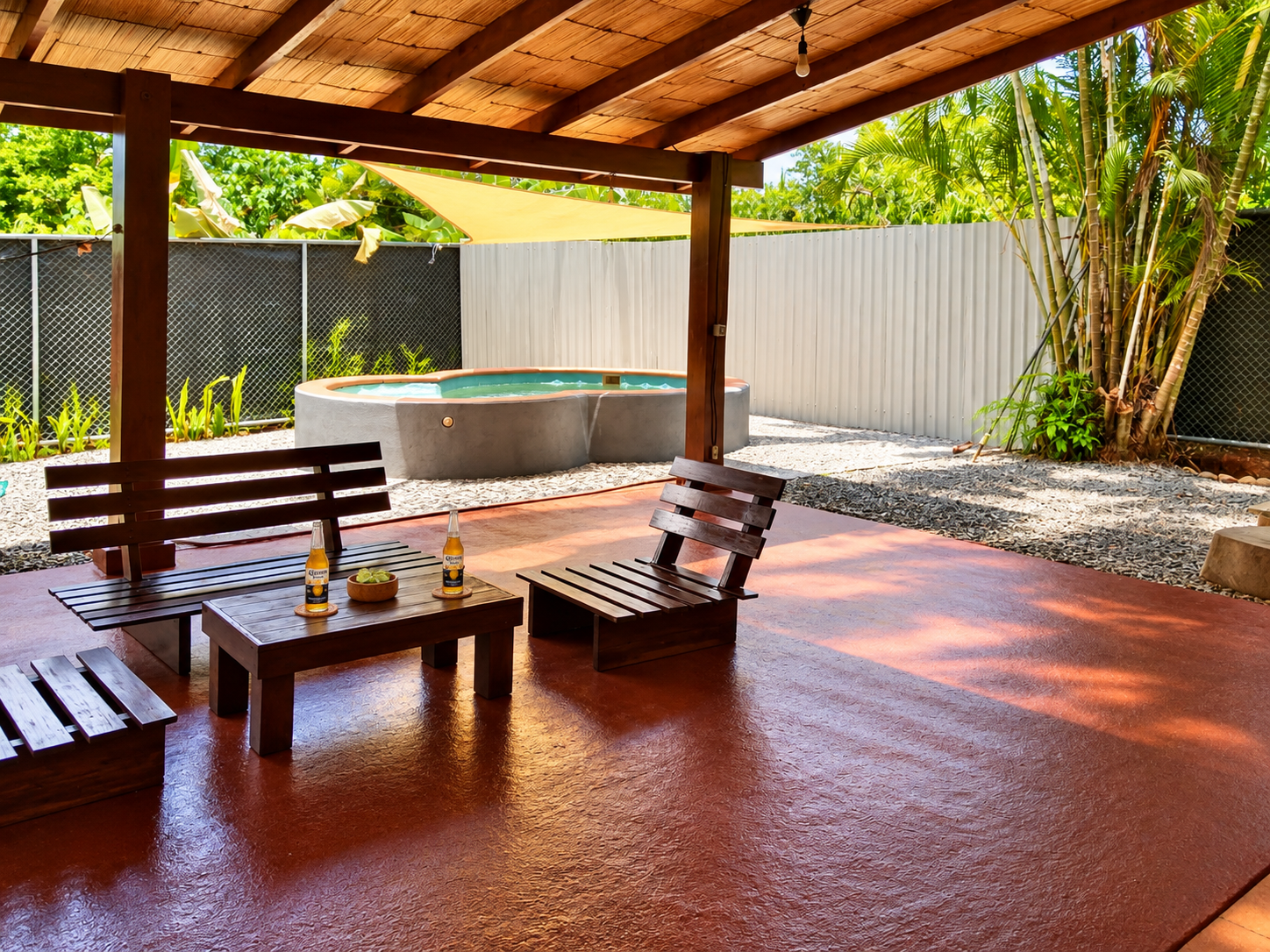 Covered tropical patio with wooden lounge furniture and private plunge pool at Casa Palma Bonita