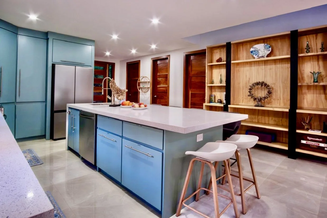 Spacious designer kitchen with Calacatta Fino quartz waterfall island, custom cabinetry and breakfast seating at House of Light in Paquera, Costa Rica