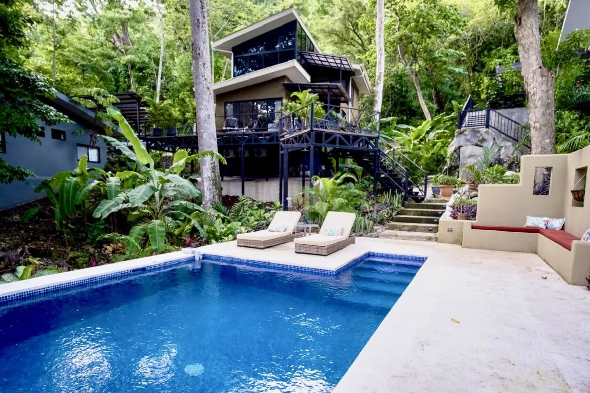 Private saltwater swimming pool with sun loungers and tropical gardens at House of Light in Paquera, Costa Rica