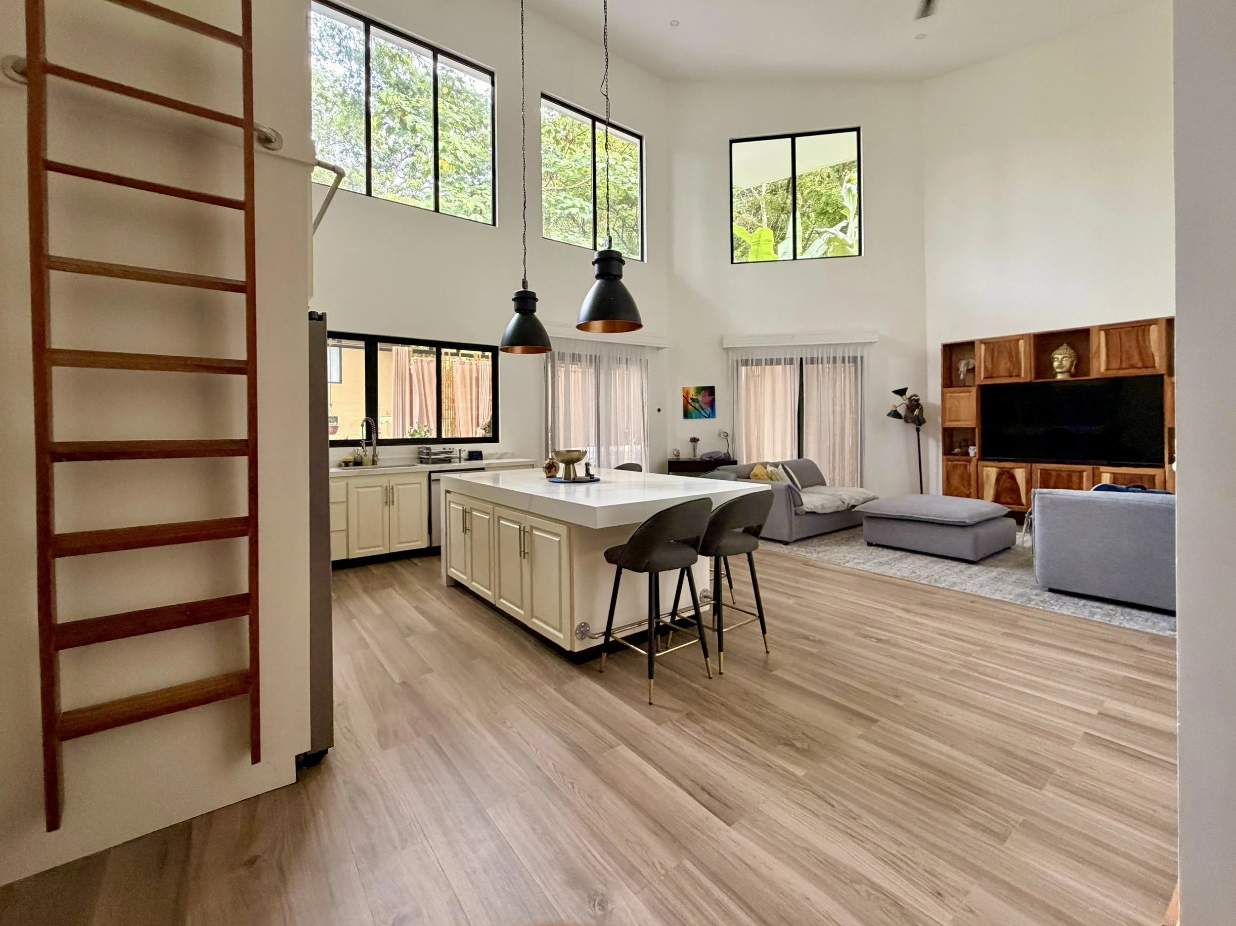 Casa Quantum bright open-plan living and kitchen area with vaulted ceilings and natural wood flooring.