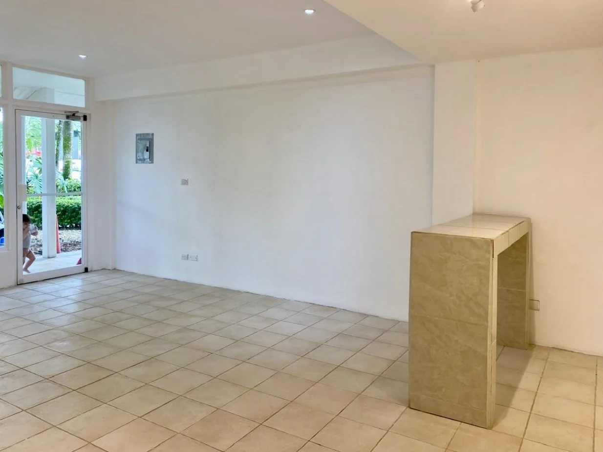 View across the tiled retail space with wall counter and recessed lighting