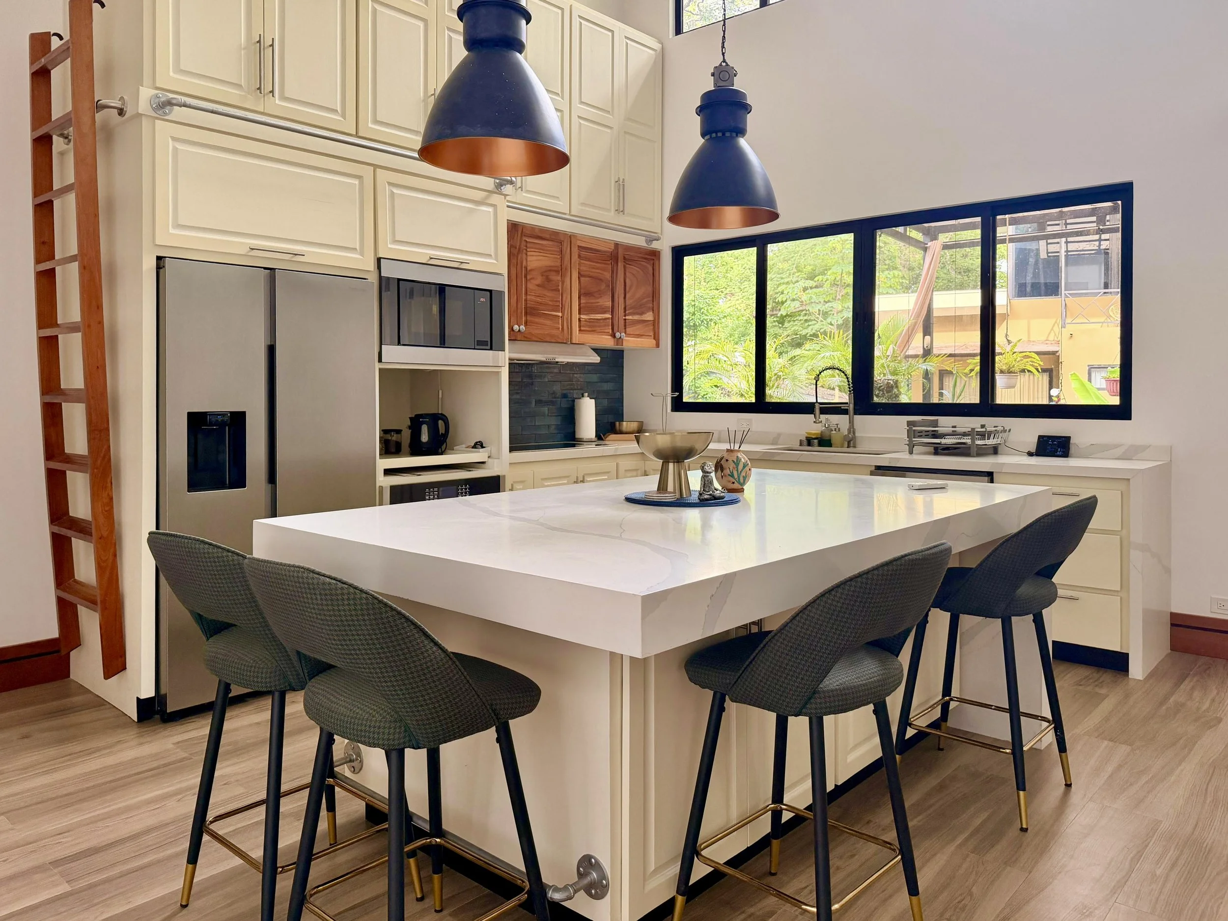 Casa Quantum modern kitchen with waterfall island, bar seating, pendant lighting and quartz countertops.